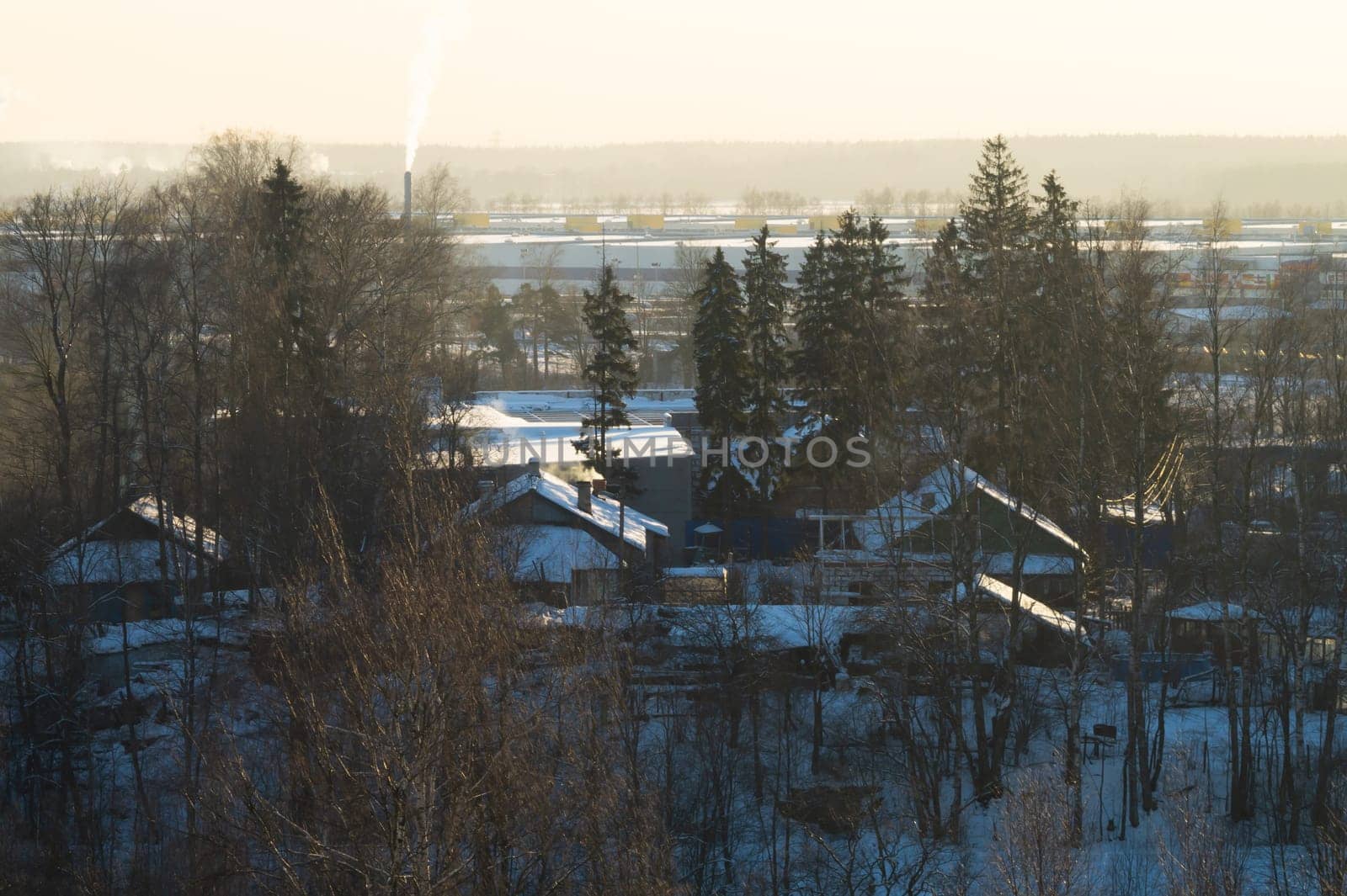 Snow covered houses with the gardens in winter. wooden houses in the forest aerial view. rural landscape from high view