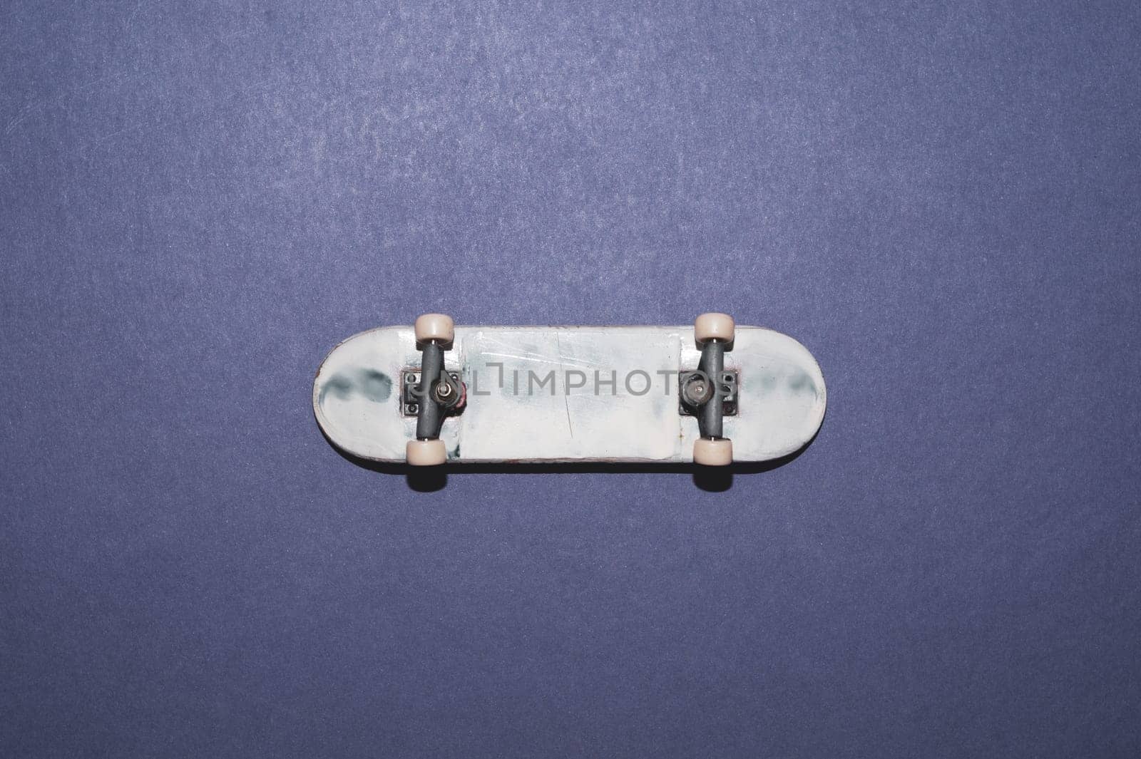 Small skateboard on color background. tiny skate for fingers. fingerboard close up. home leisure concept. copy space