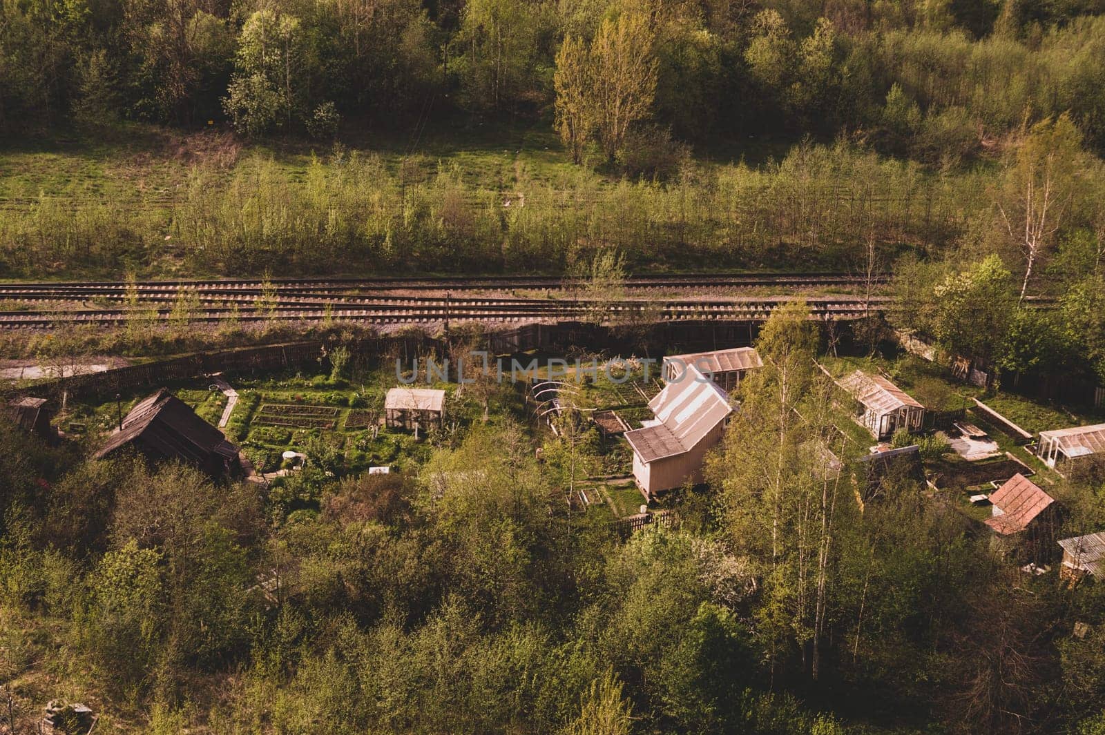House with the garden near railway lines. wooden house in the forest aerial view. rural landscape from high view
