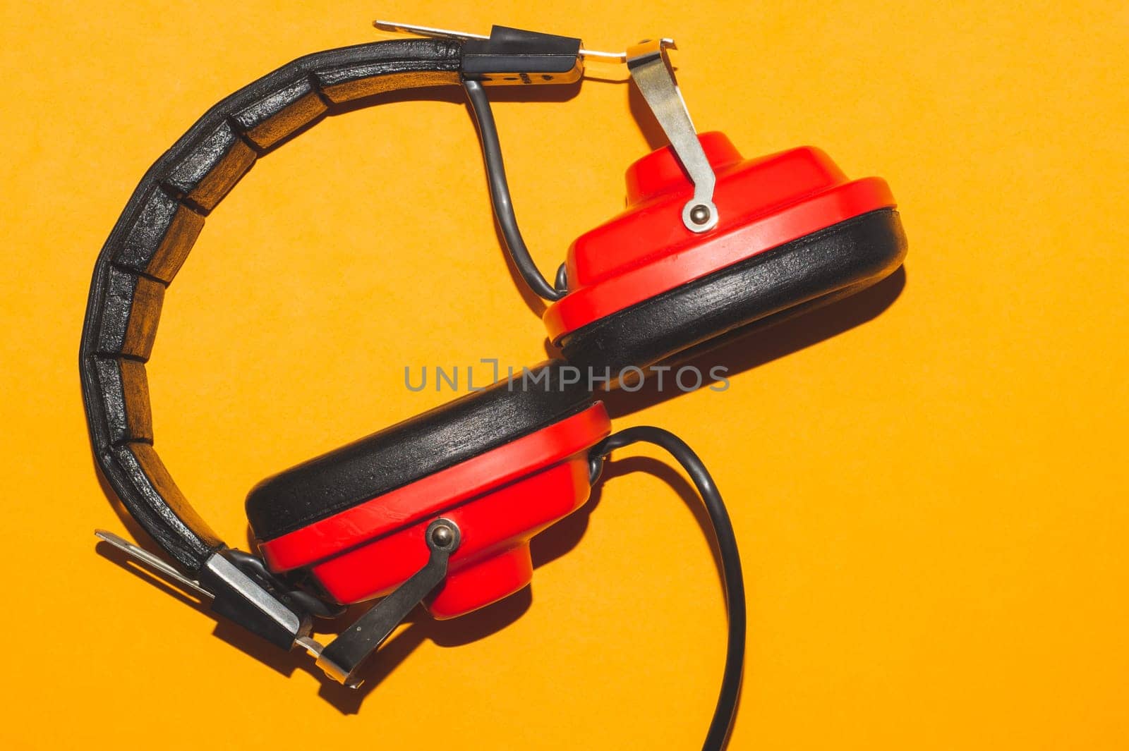Vintage red headphones on yellow background. retro earphones