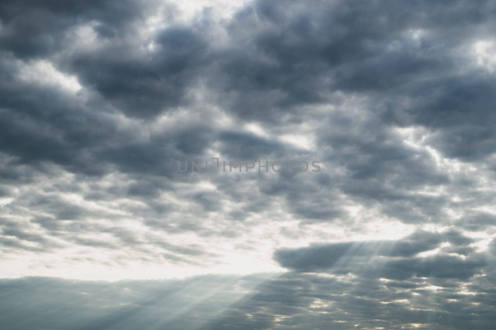 Sunlight shines through the cloudy sky. stormy sky with sunbeam. overcast weather