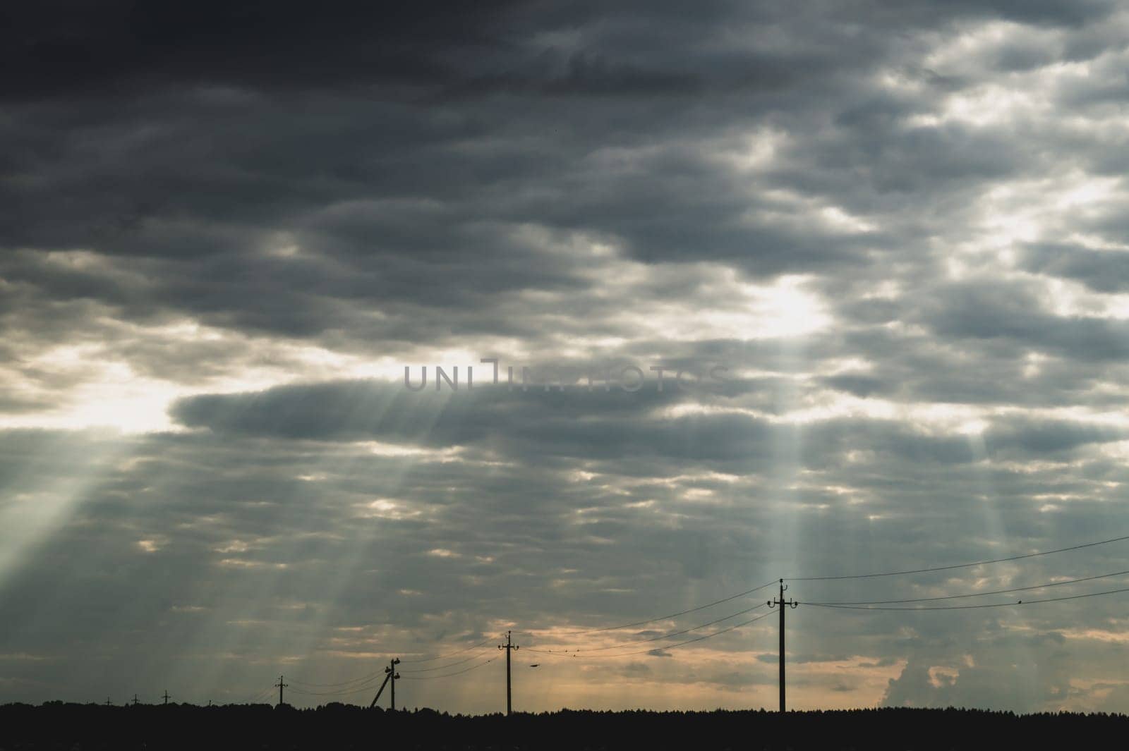 Sunlight shines through the cloudy sky. stormy sky with sunbeam. overcast weather. horizon line