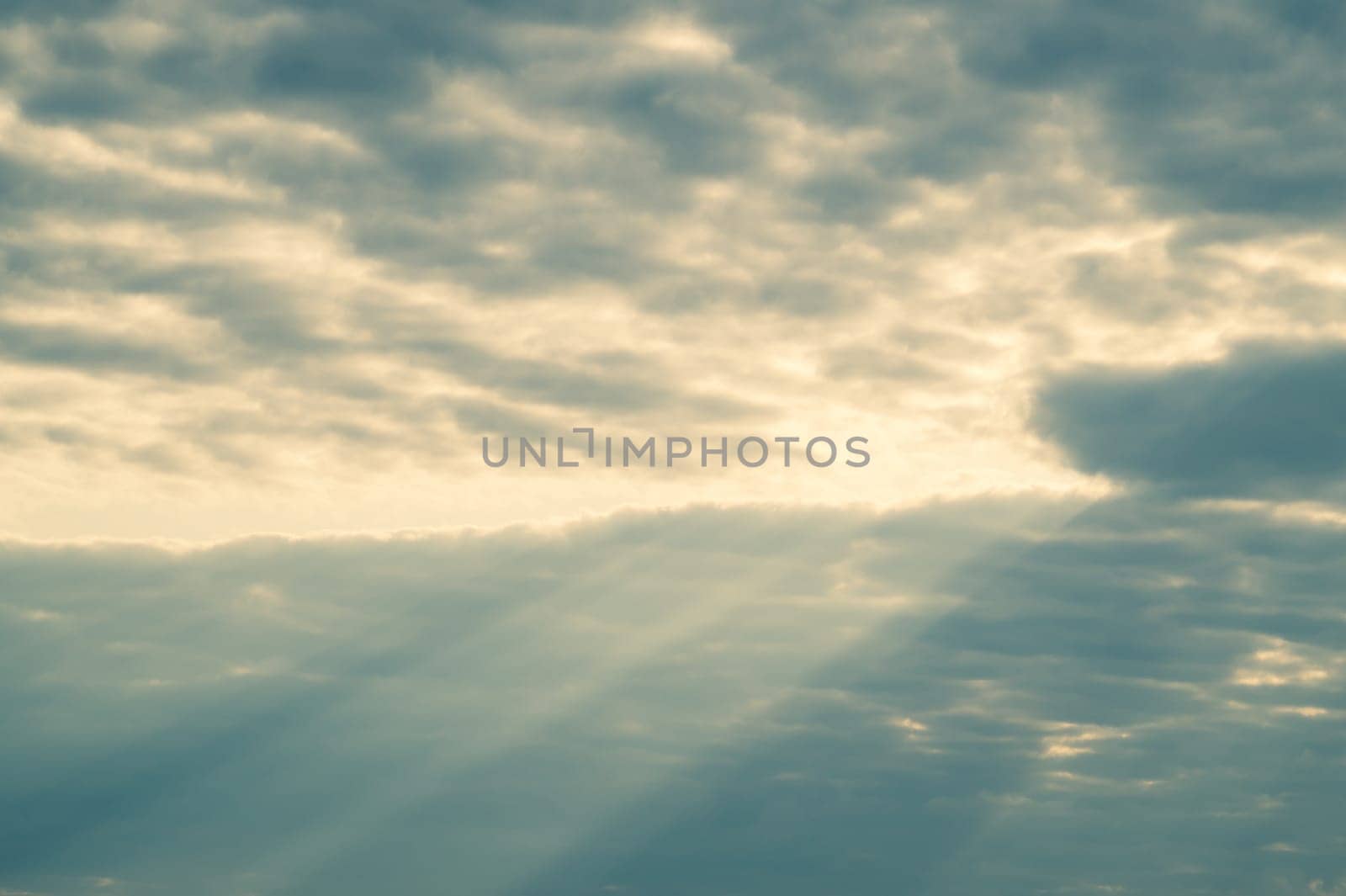 Sunlight shines through the cloudy sky. stormy sky with sunbeam. overcast weather