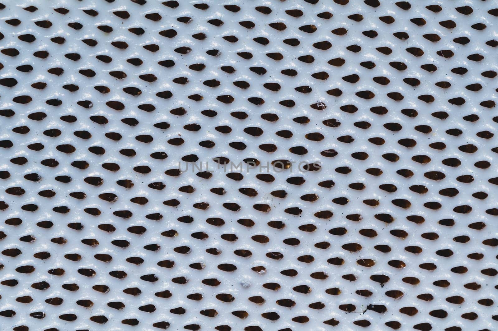 Rubber surface with uneven holes. white plastic texture with dots. abstract background