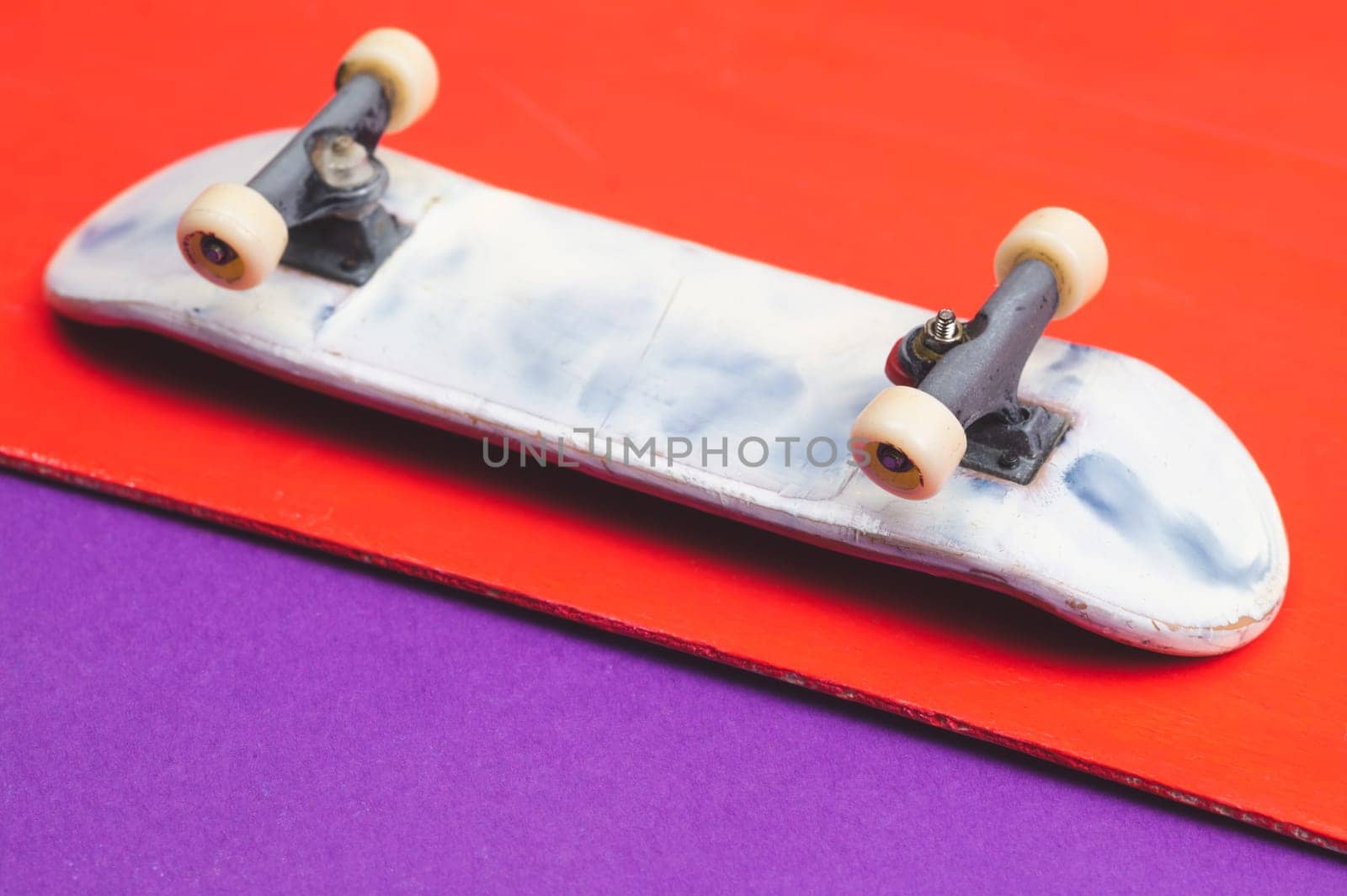 Small skateboard on color background. tiny skate for fingers. fingerboard close up. copy space
