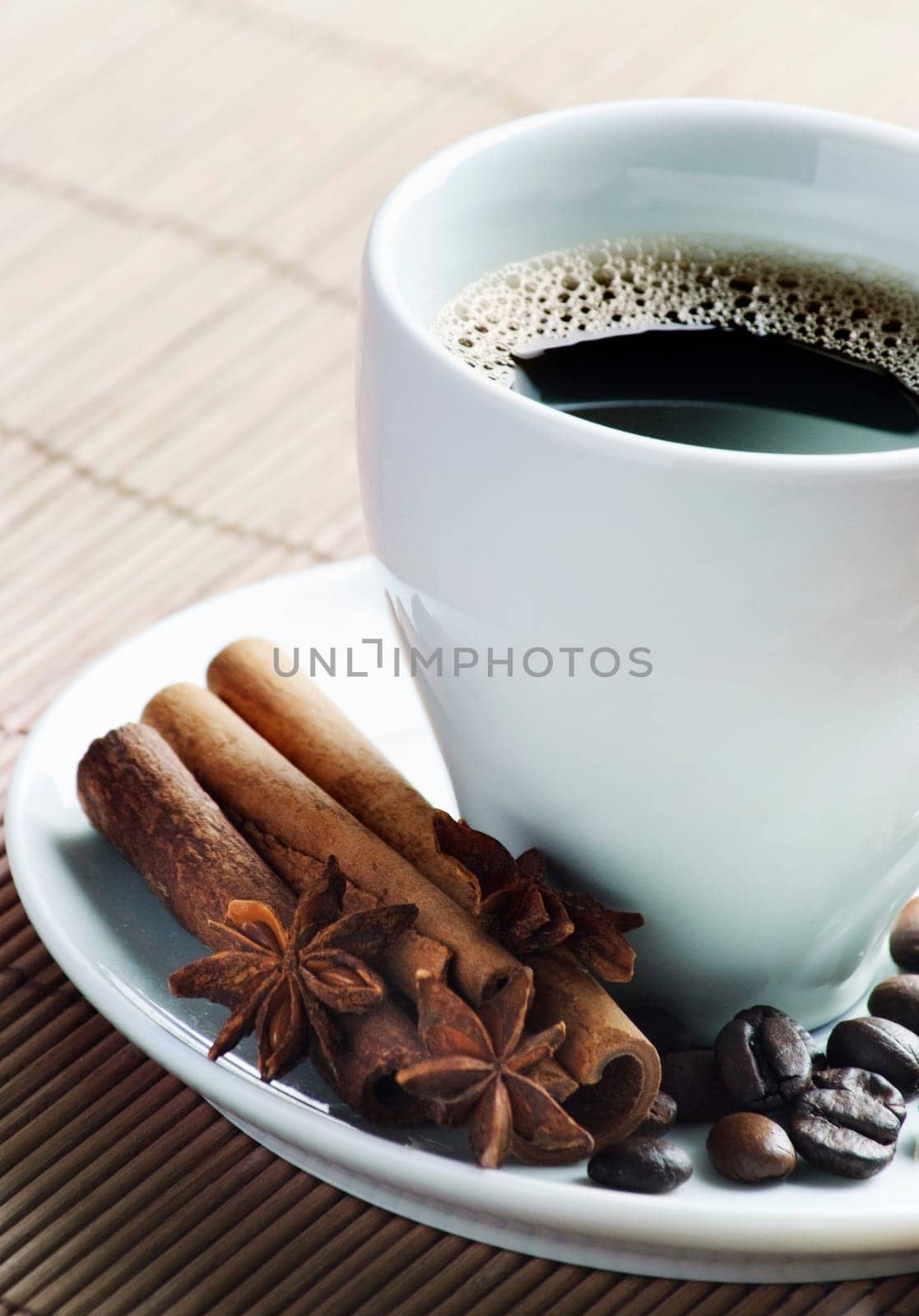 Cup of coffee with cinnamon and coffee beans