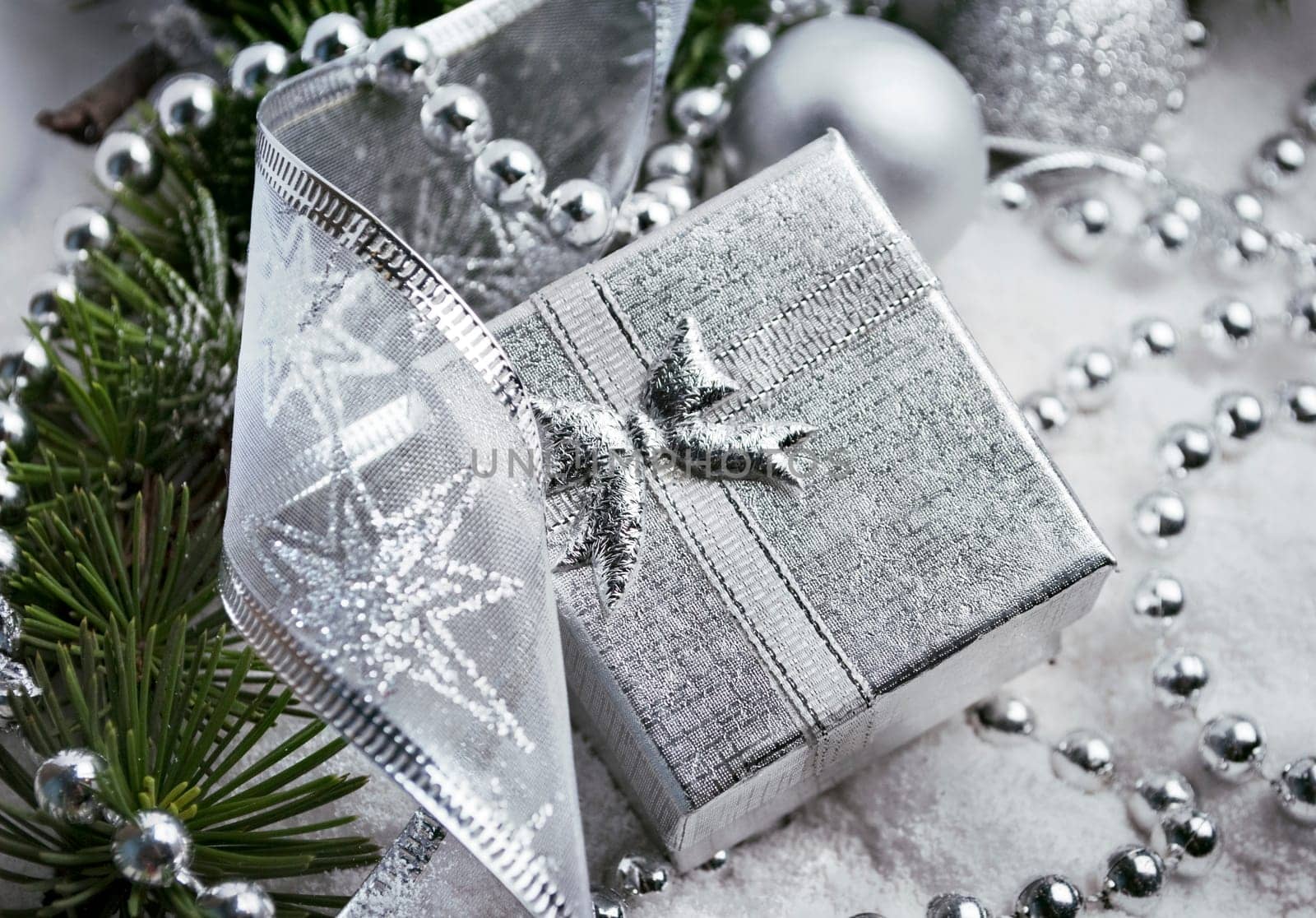Silver gift box and christmas decoration in fake snow