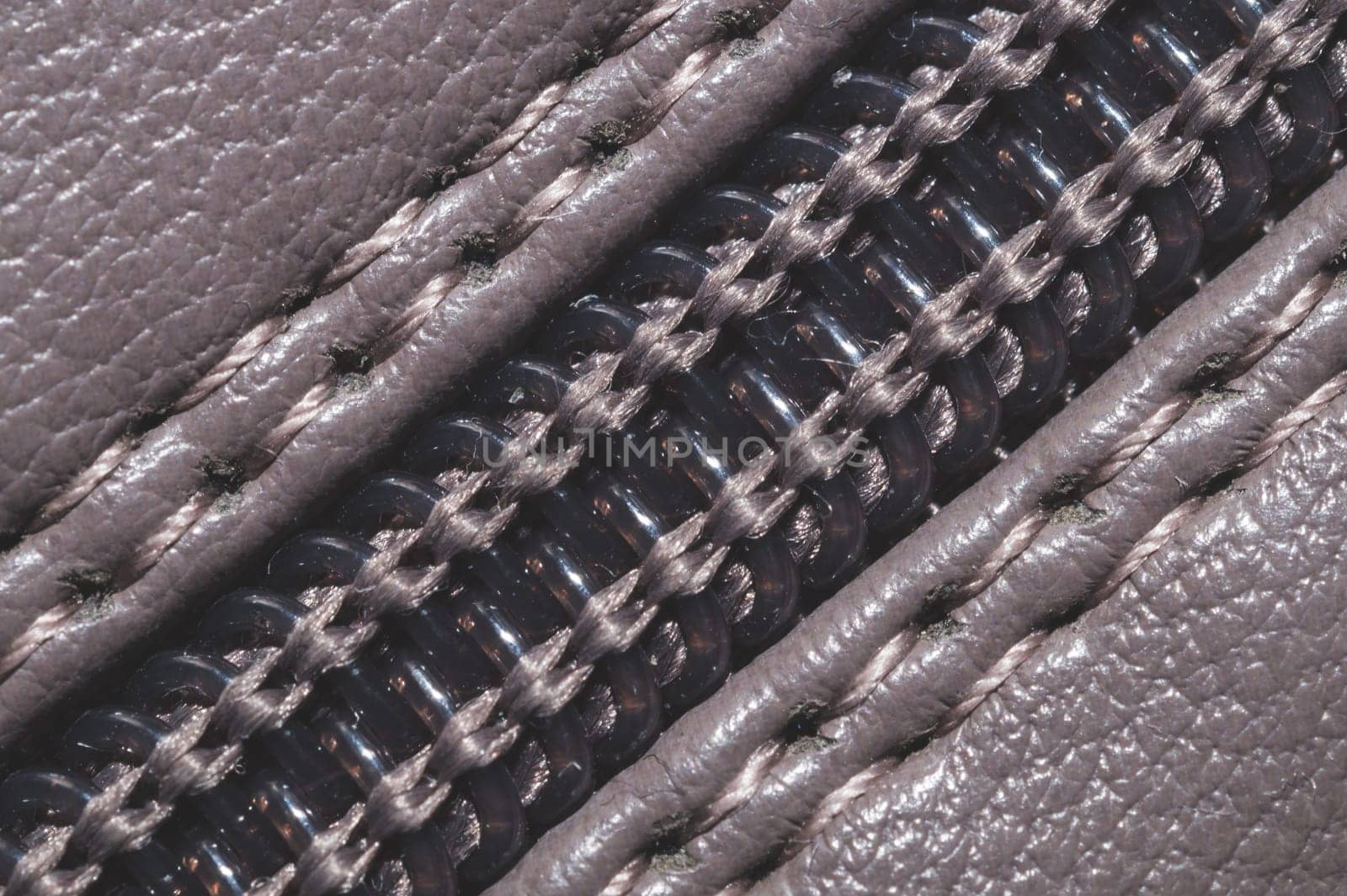 Leather background with zipper closure. material with seams close up