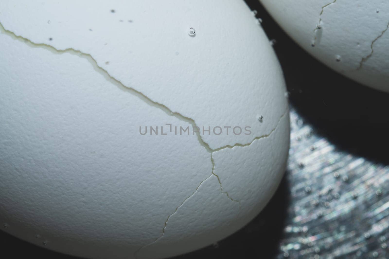 Cracked egg boiled in a pot with hot water close up
