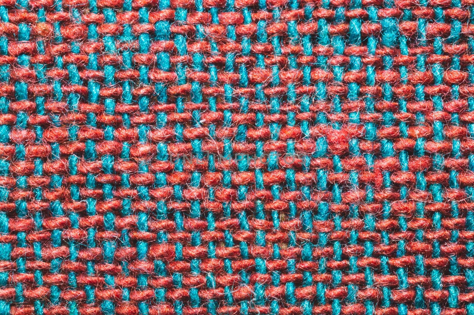 Fabric macro texture. knitted textile close up. woven background. woolen material. weaving red and blue threads