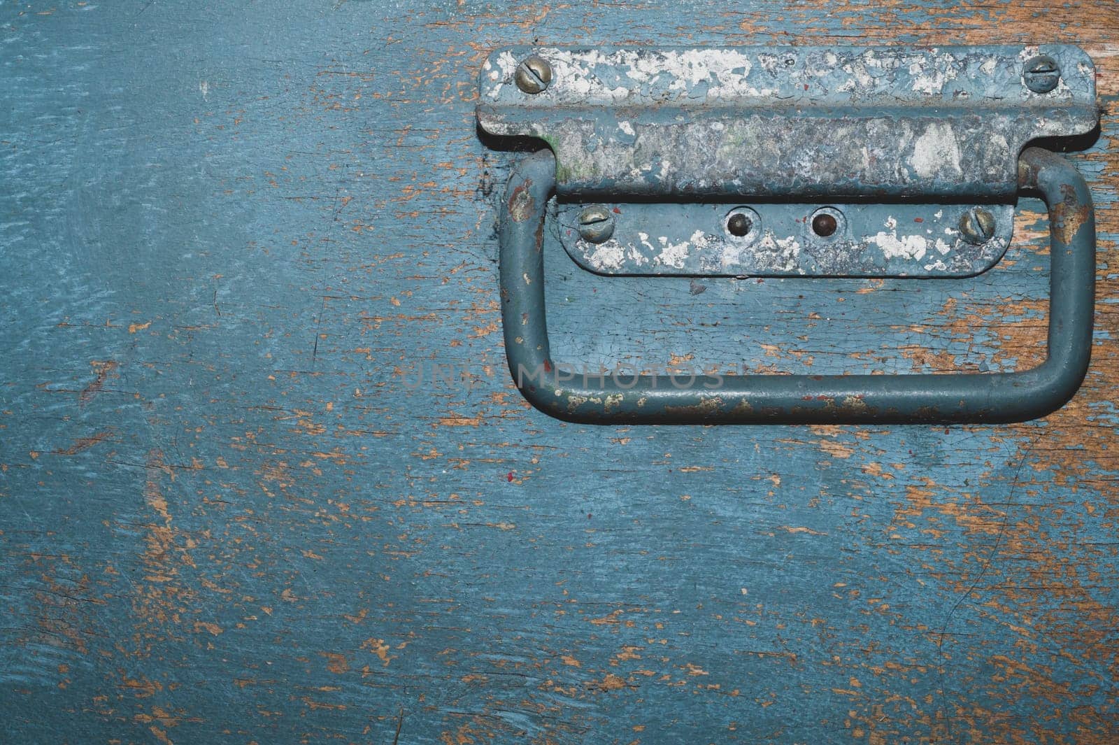 Shabby wood surface with metal handle. old wooden box with cracked paint. abstract background