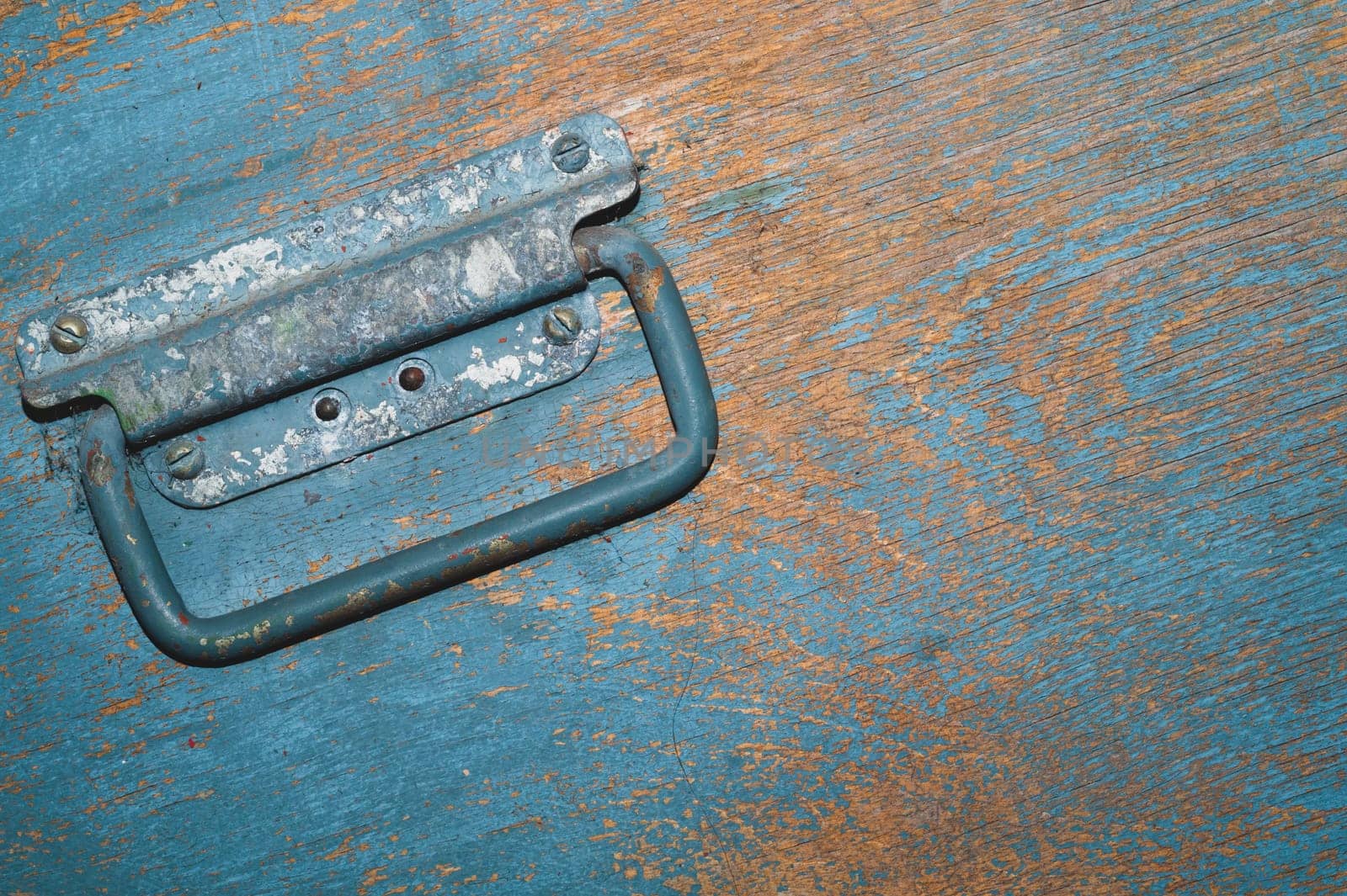 Shabby wood surface with metal handle. old wooden box with cracked paint. abstract background
