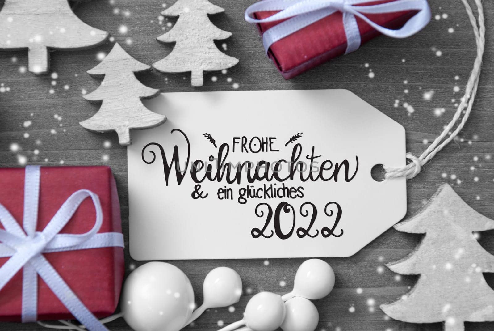 One Label With German Calligraphy Frohe Weihnachten Und Ein Glueckliches 2022 Means Merry Christmas And Happy 2022. Christmas Decoration Like Gifts And Trees. Wooden Background WIth Snowflakes