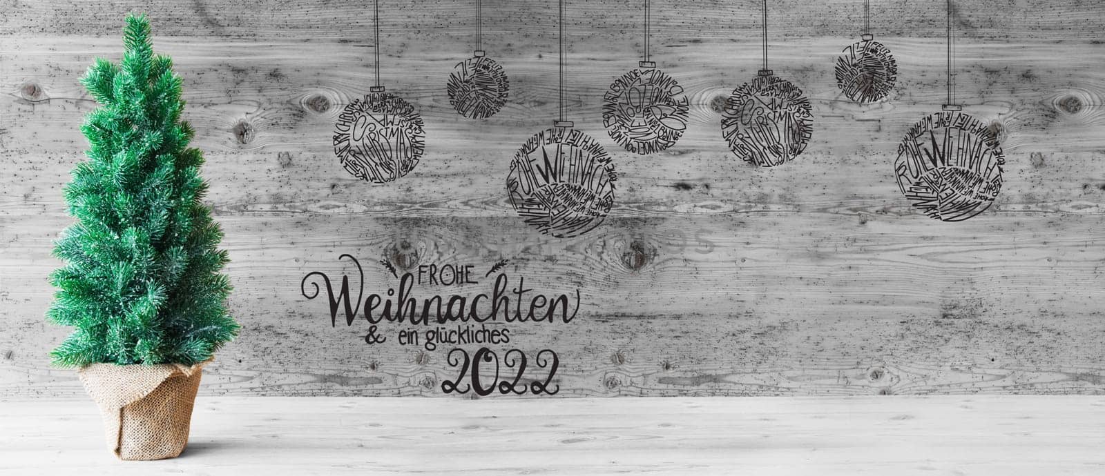 Wooden Background WIth German Calligraphy Frohe Weihnachten Und Ein Glueckliches 2022 Means Merry Christmas And A Happy 2022. Christmas Tree And Illustrated Decoration Like Balls. Black And White