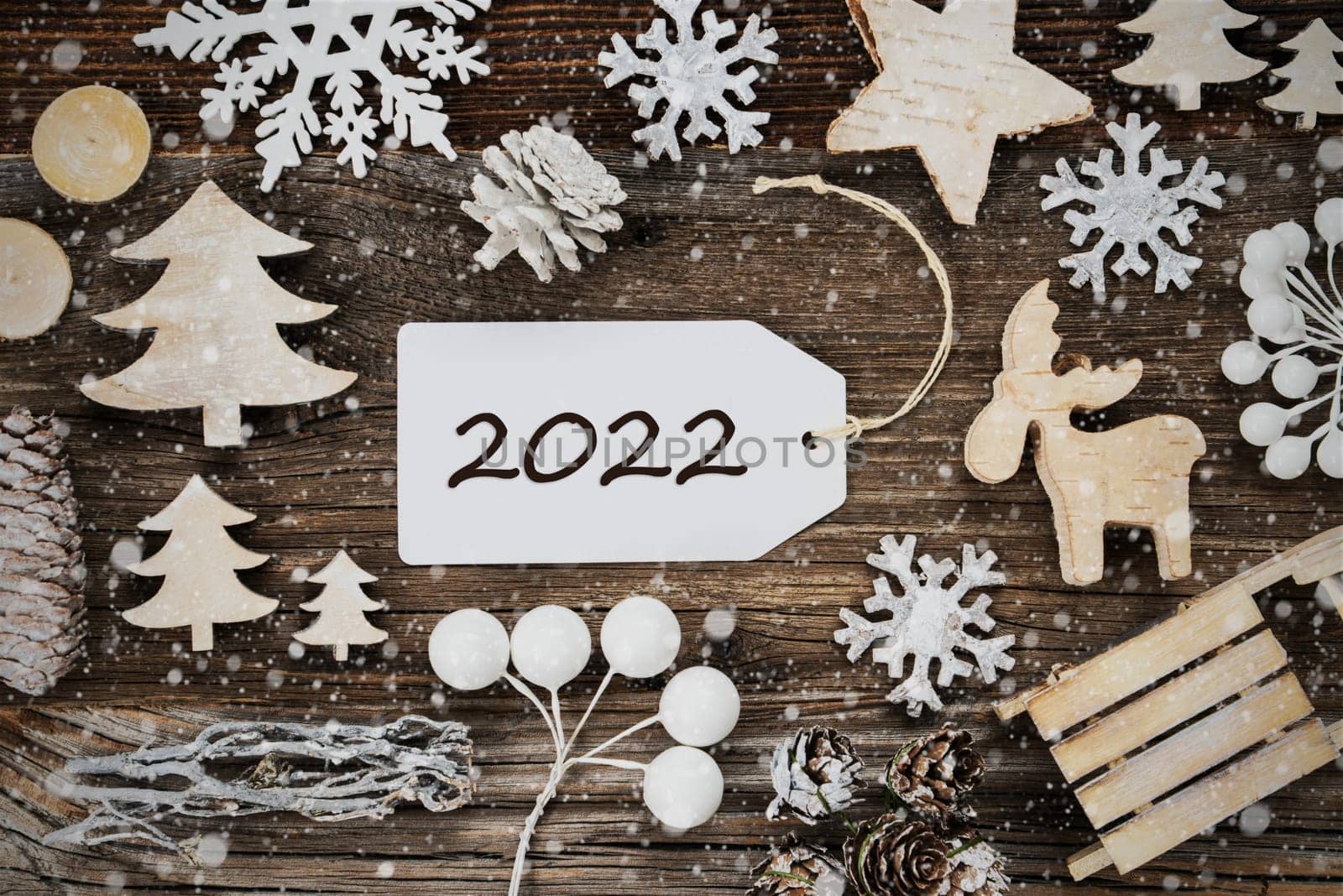 One White Label With Text 2022. Frame Of Christmas Decoration Like Tree, Sled, Star And Fir Cone. Wooden Background With Snowflakes