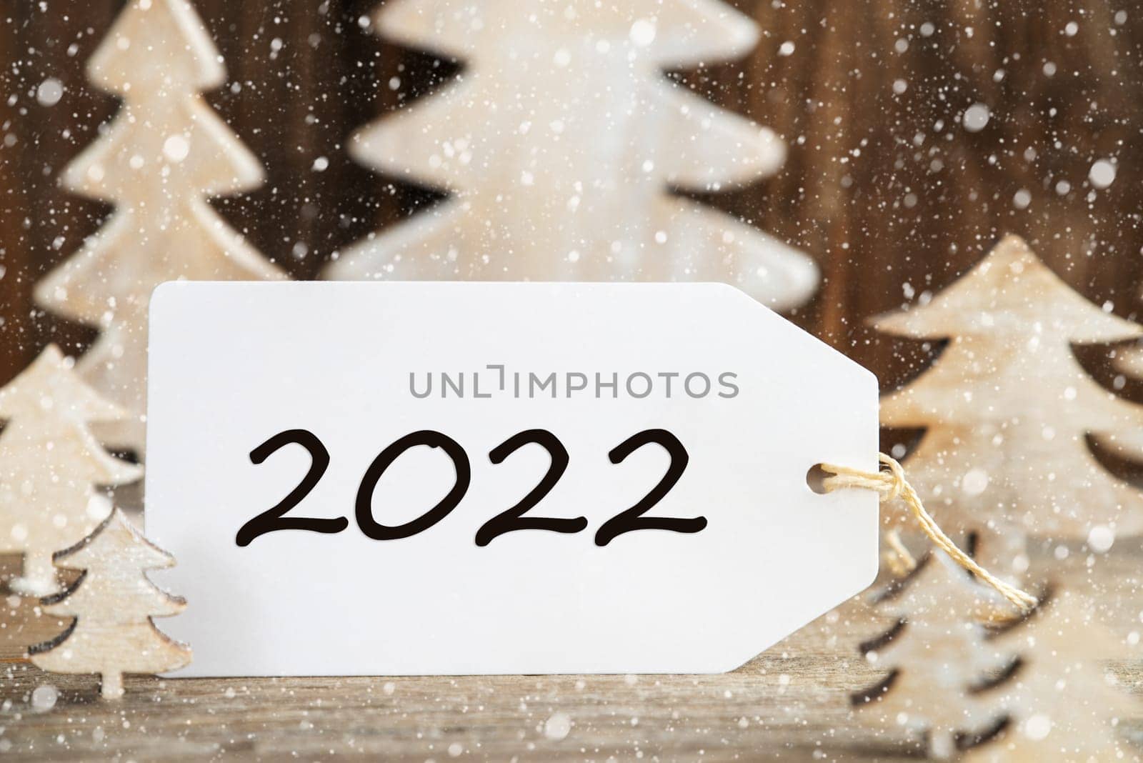 Label With Text 2022. White Wooden Christmas Tree As Decoration. Brown Wooden Background With Snow