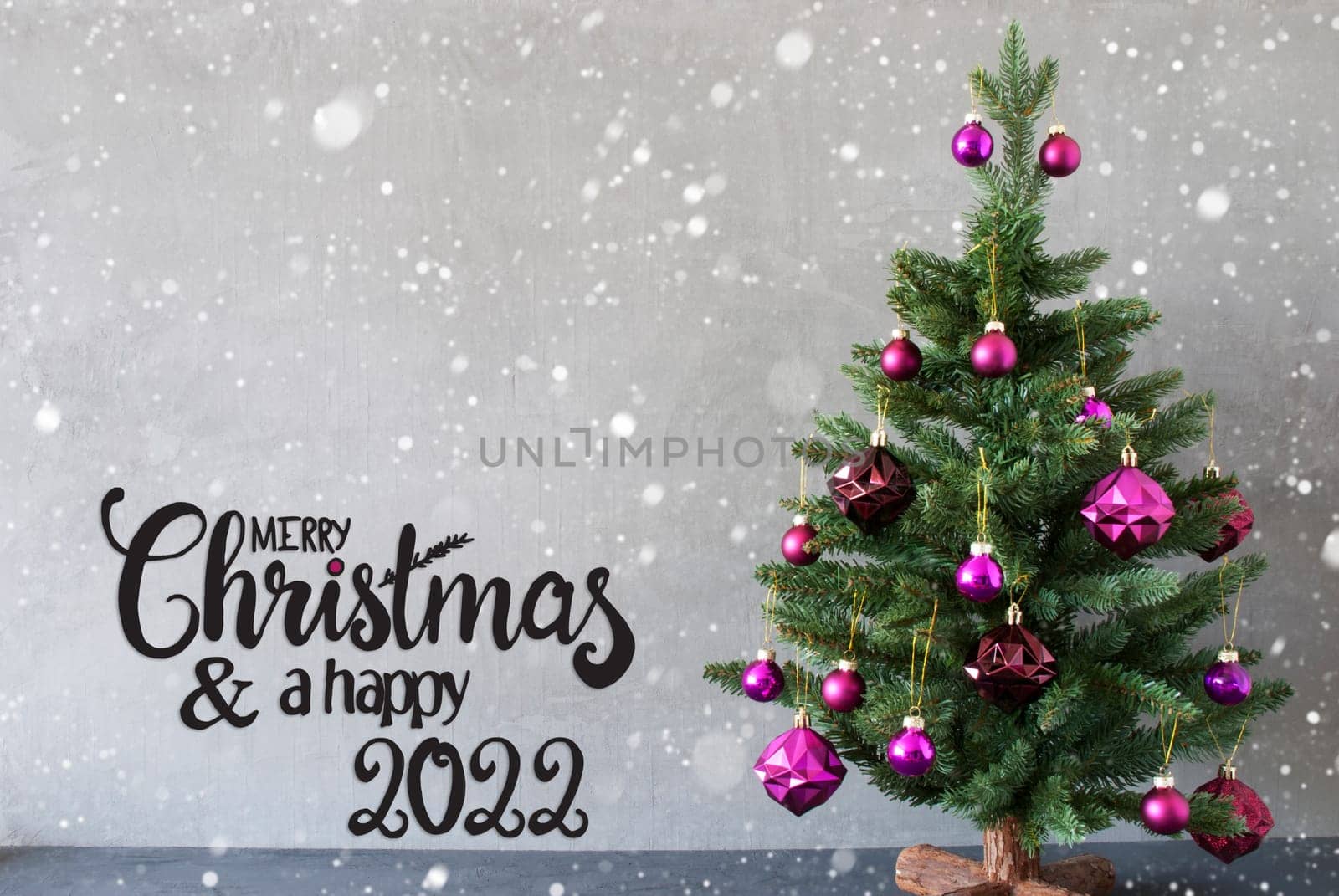 English Calligraphy Merry Christmas And A Happy 2022. Tree With Purple Christmas Ball Ornament. Gray Background With Snowflakes