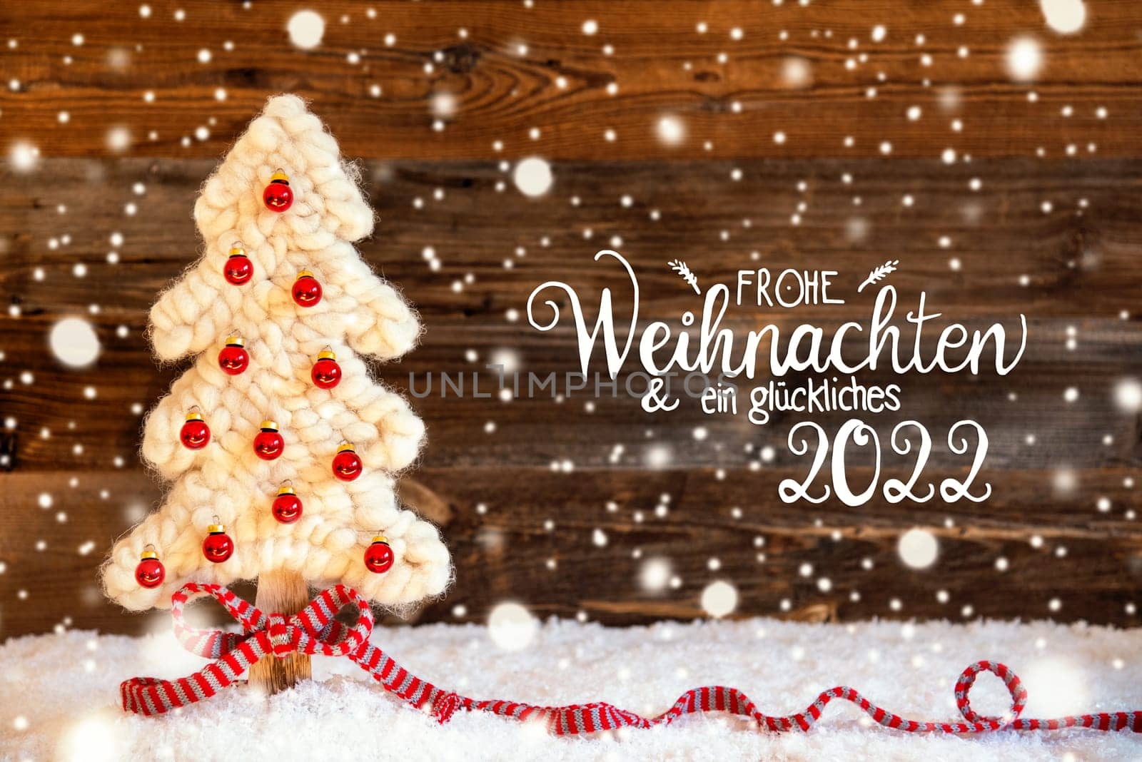 German Calligraphy Frohe Weihnachten Und Ein Glueckliches 2022 Means Merry Christmas And A Happy 2022. White Fabric Christmas Tree With Red Ball Ornament. Wooden Background With Snow And Snowflakes