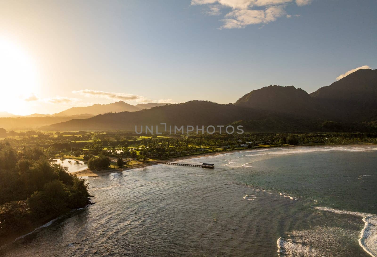 Aerial panoramic image at sunrise off the coast over Hanalei Bay and pier on Hawaiian island of Kauai
