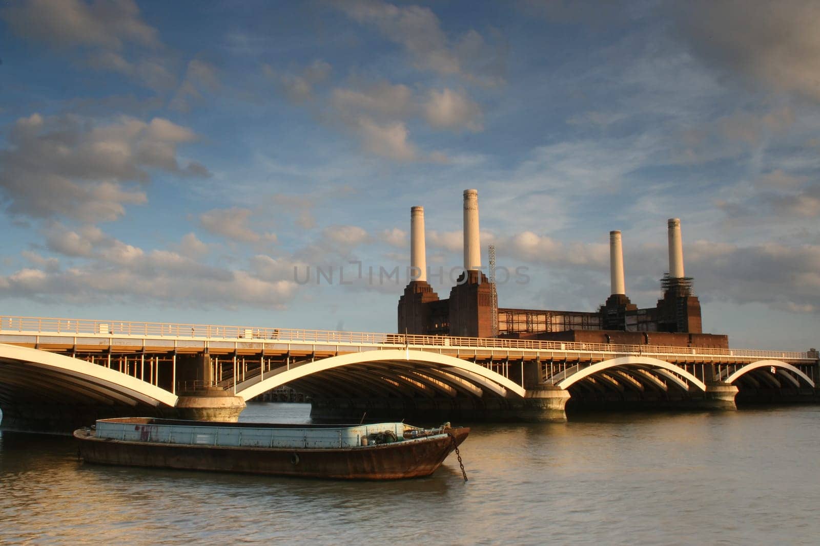 The River Thames at dusk with barge Grosvenor Rail Bridge and Battersea Power Station