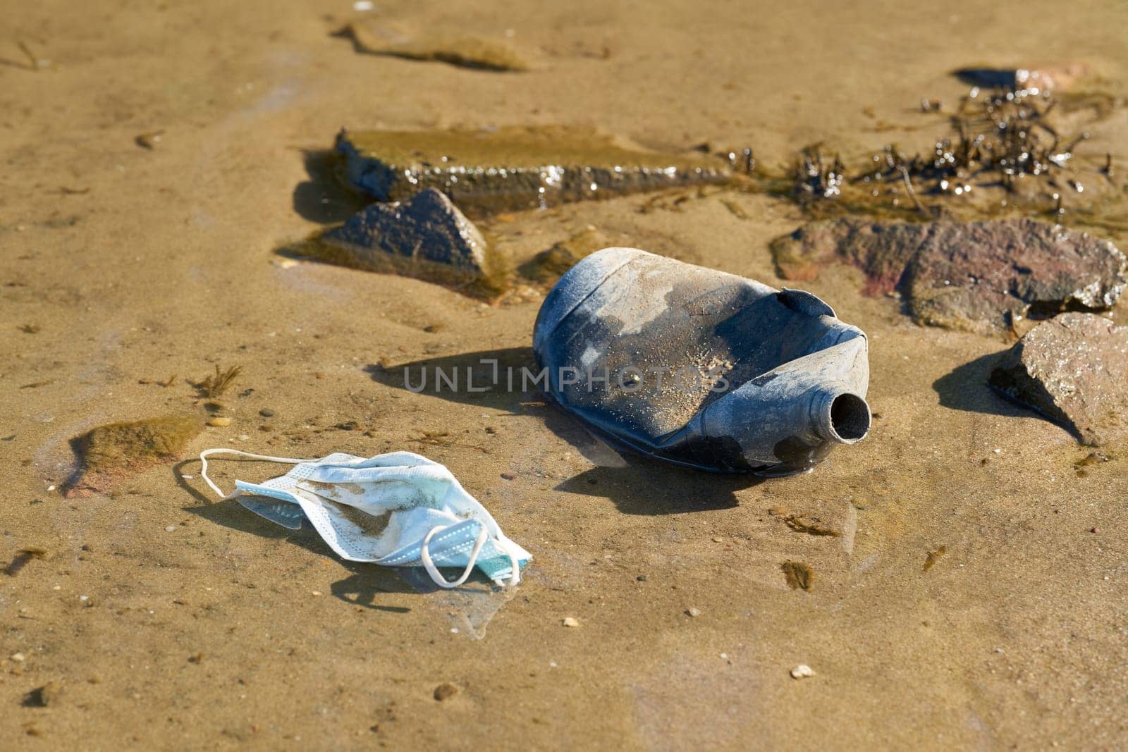 Bottle made of plastic and face mask on the bank of the Elbe near Magdeburg