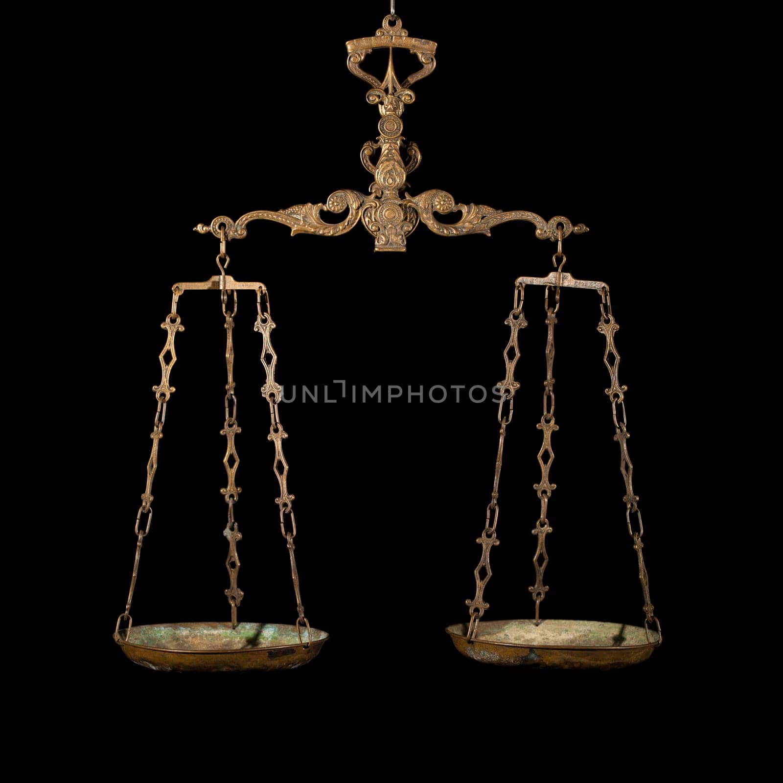 Antique rusty balance scale isolated on black background. Justice and making decision concept. Even odds, being in balance.