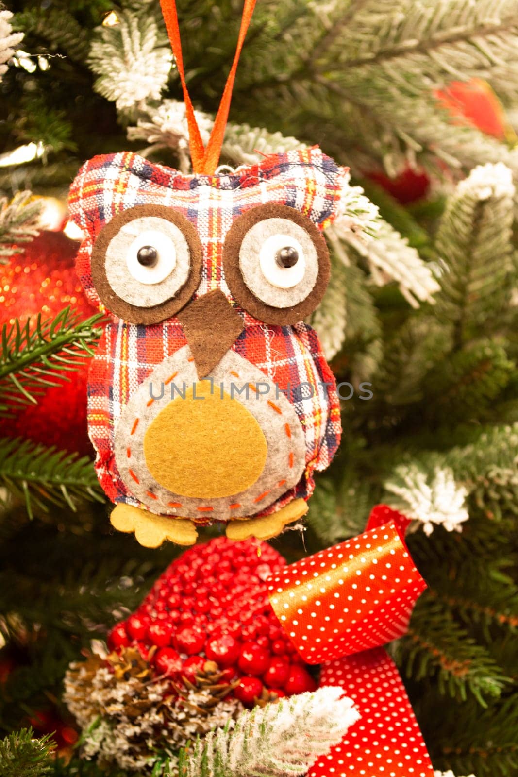Close up view of cute Christmas tree decoration in form of owl figure. Christmas holidays concept. Vertical image