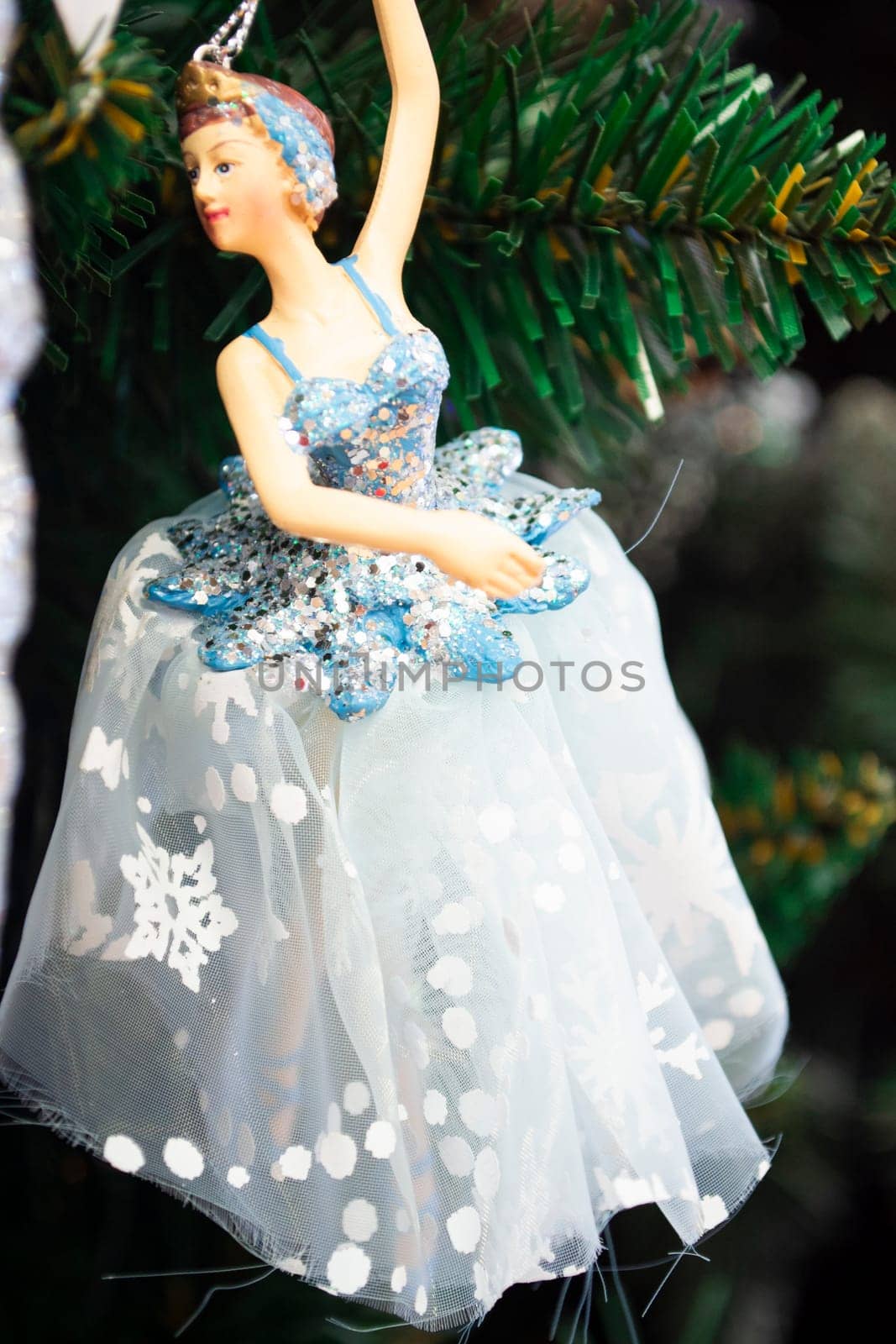 Ballerina toy decoration on a Christmas tree branch. Vertical image