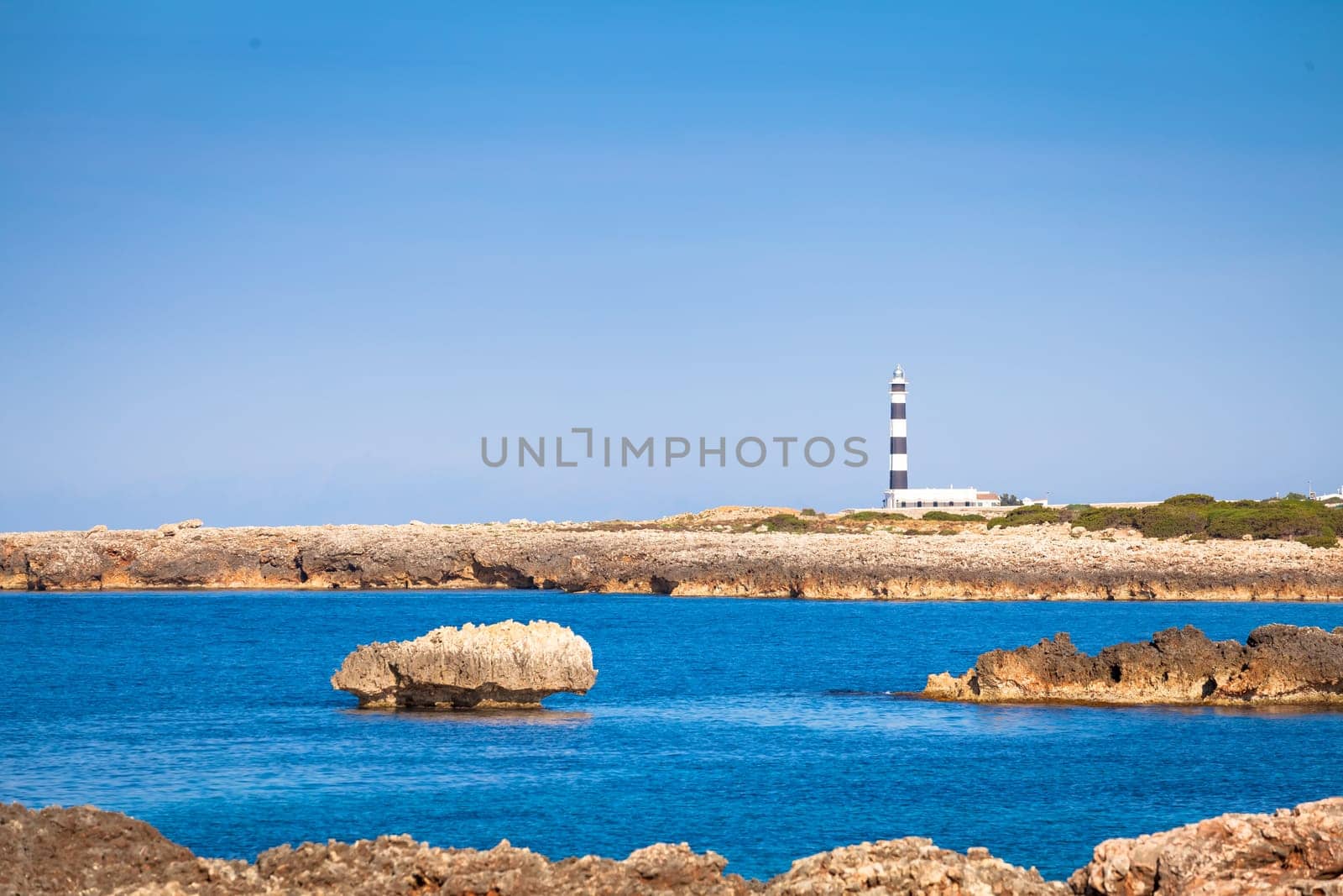 MINORCA ISLE - SPAIN - CIRCA AUGUST 2020: scenic Artrutx Lighthouse at sunset, famous landmark of the Isle