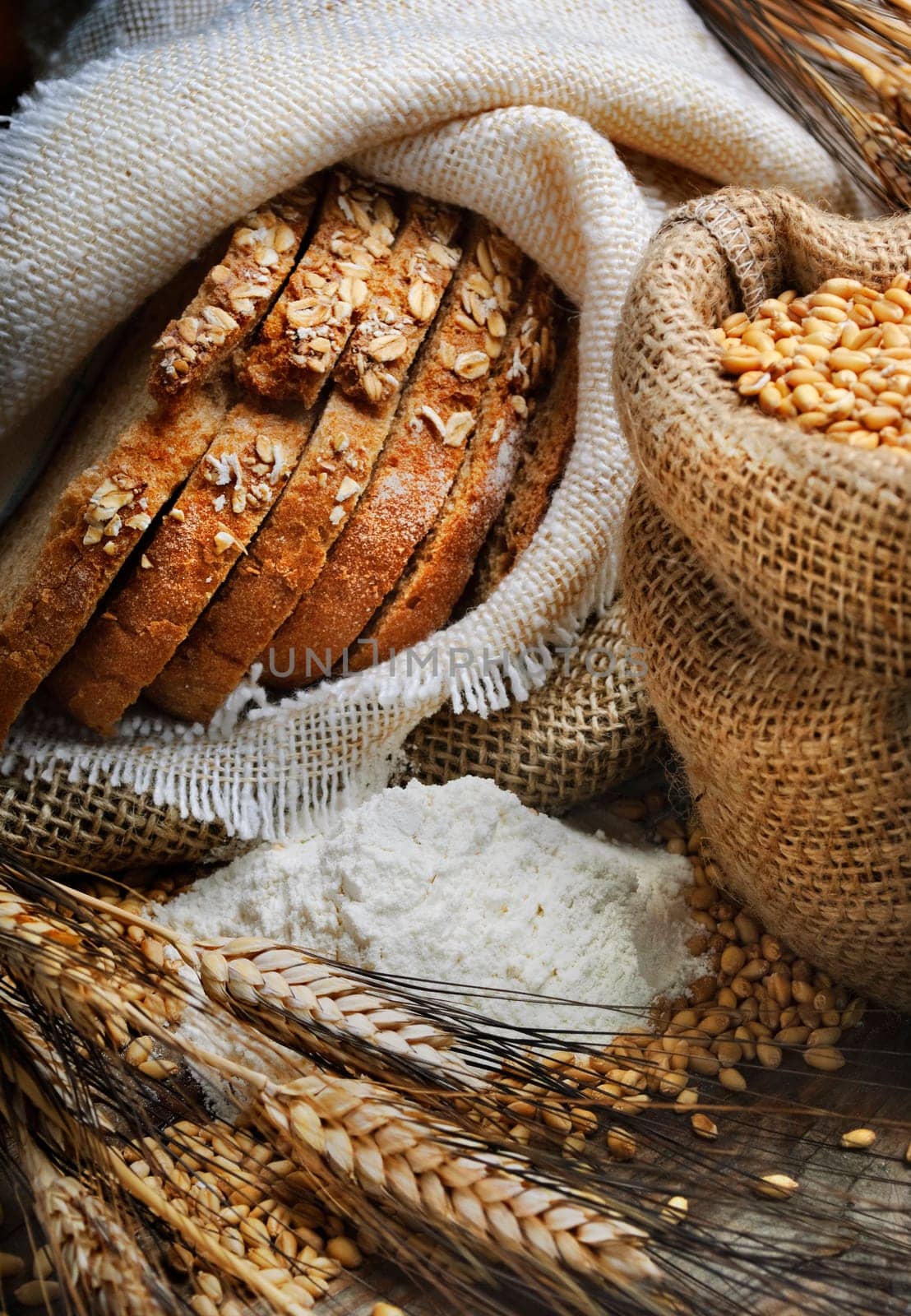 Bread and wheat ears on vintage wooden board