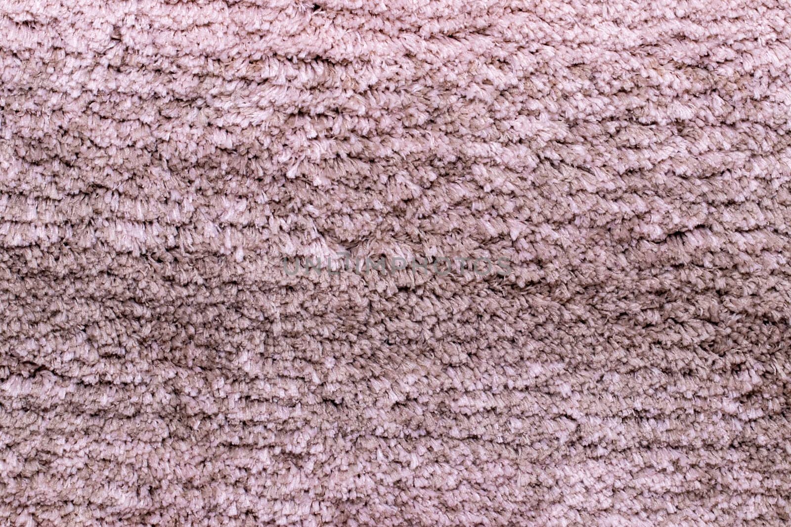 Red brown fabric texture. Close-up of a pink fluffy soft bath mat or rug or textile background. Macro photograph. Beautiful bright backdrop.