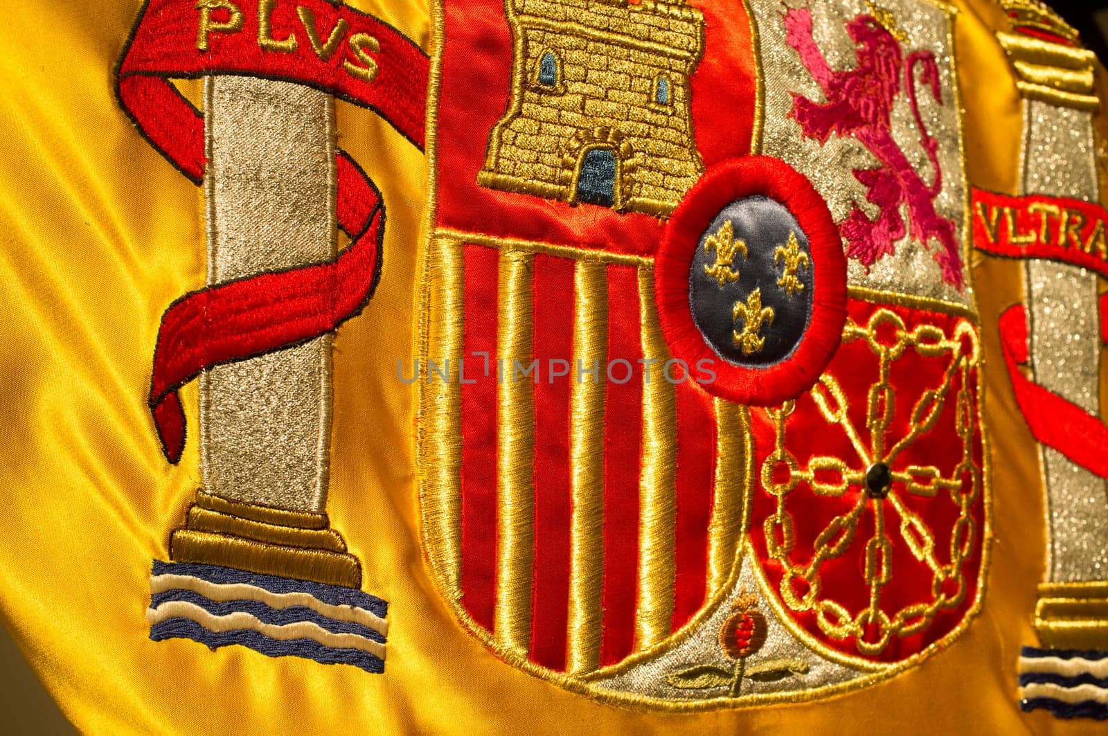 Coat of arms of Spain nation richly embroidered on its flag. Closeup