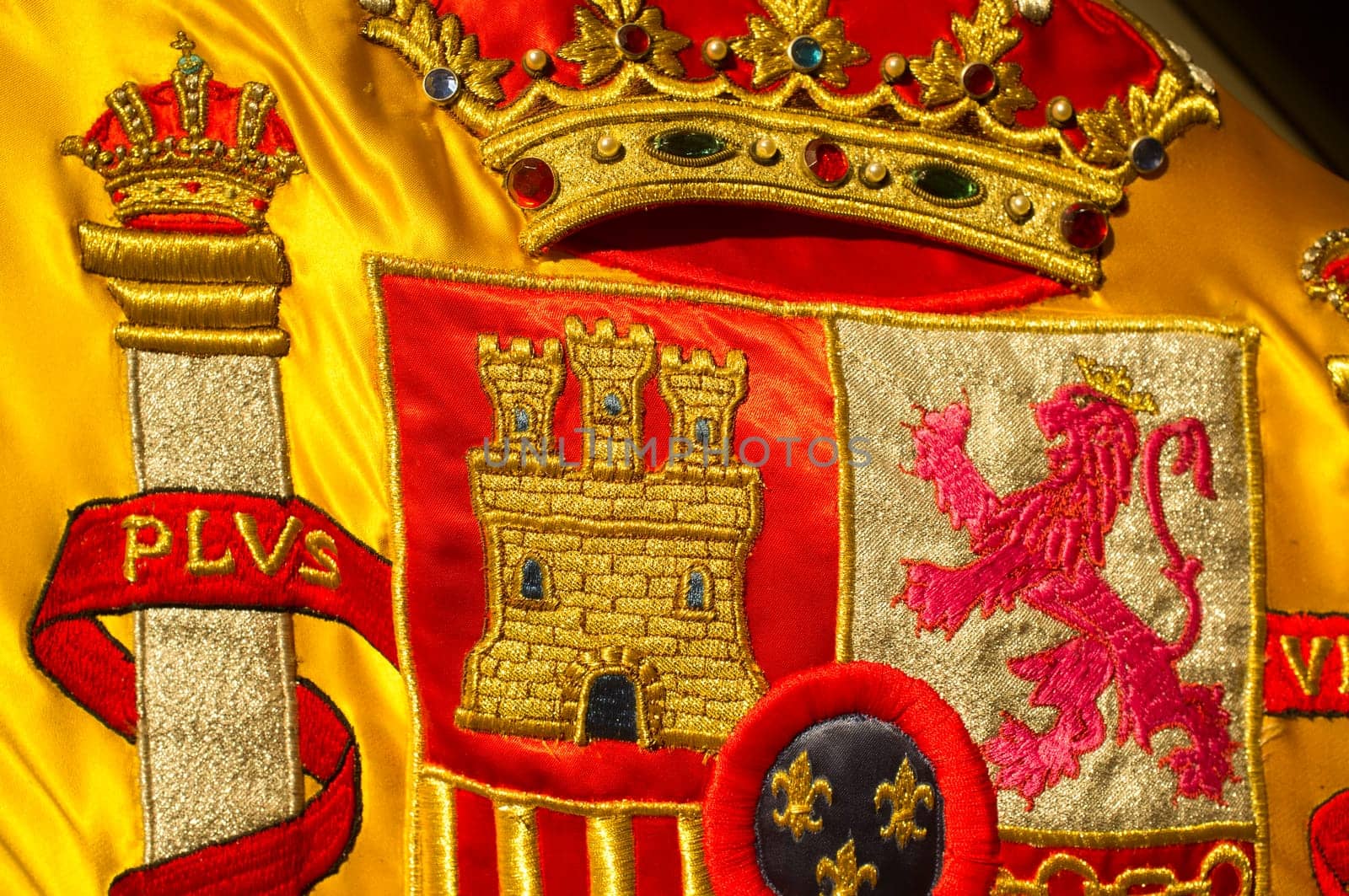 Coat of arms of Spain nation richly embroidered on its flag. Closeup