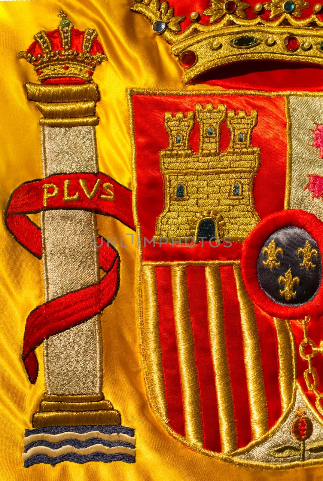 Coat of arms of Spain nation richly embroidered on its flag. Closeup