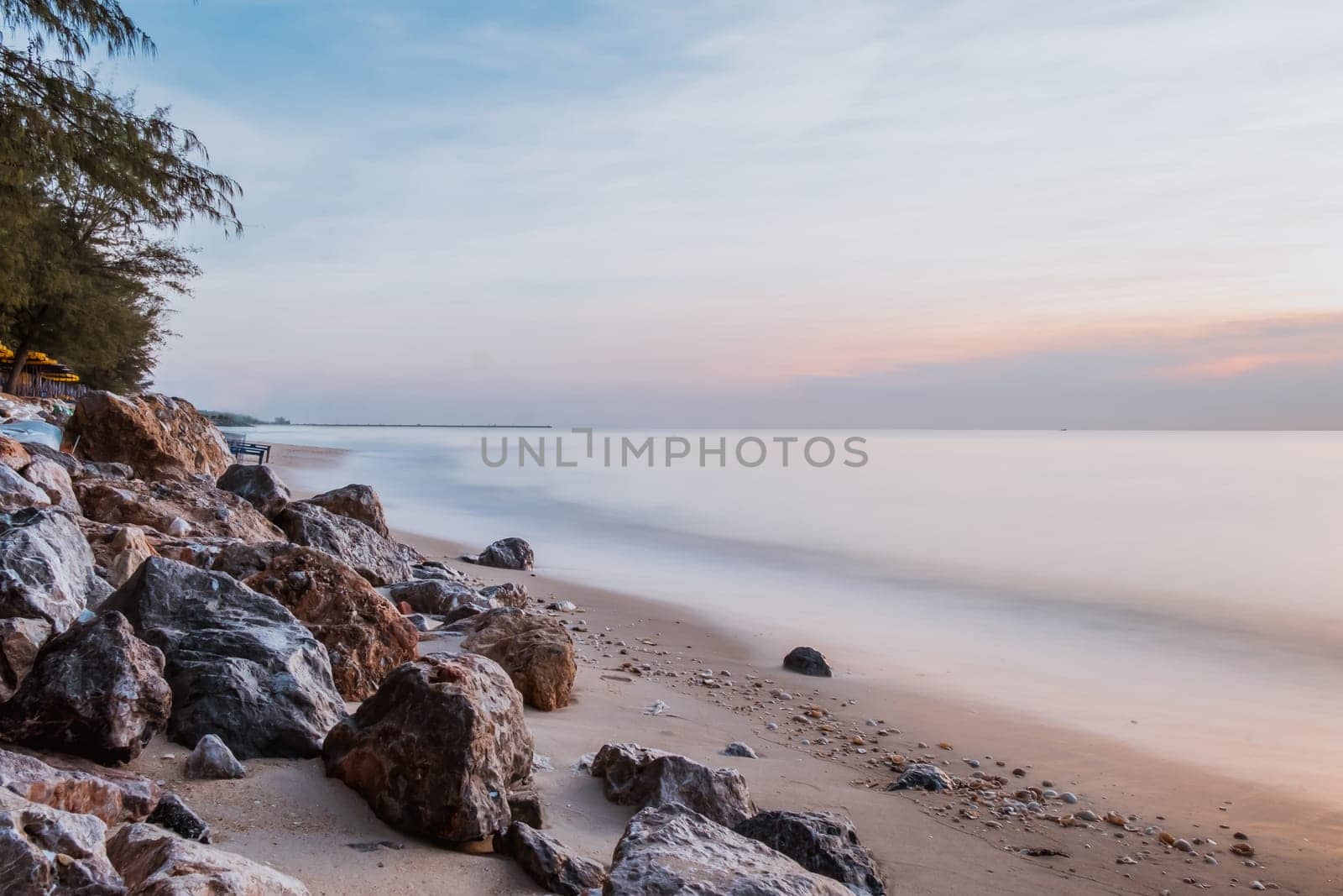 long exposure Sea rocks landscape Magnificent sunrise view at sunrise Romantic atmosphere in peaceful morning at sea. Pink horizon with first hot sun rays.