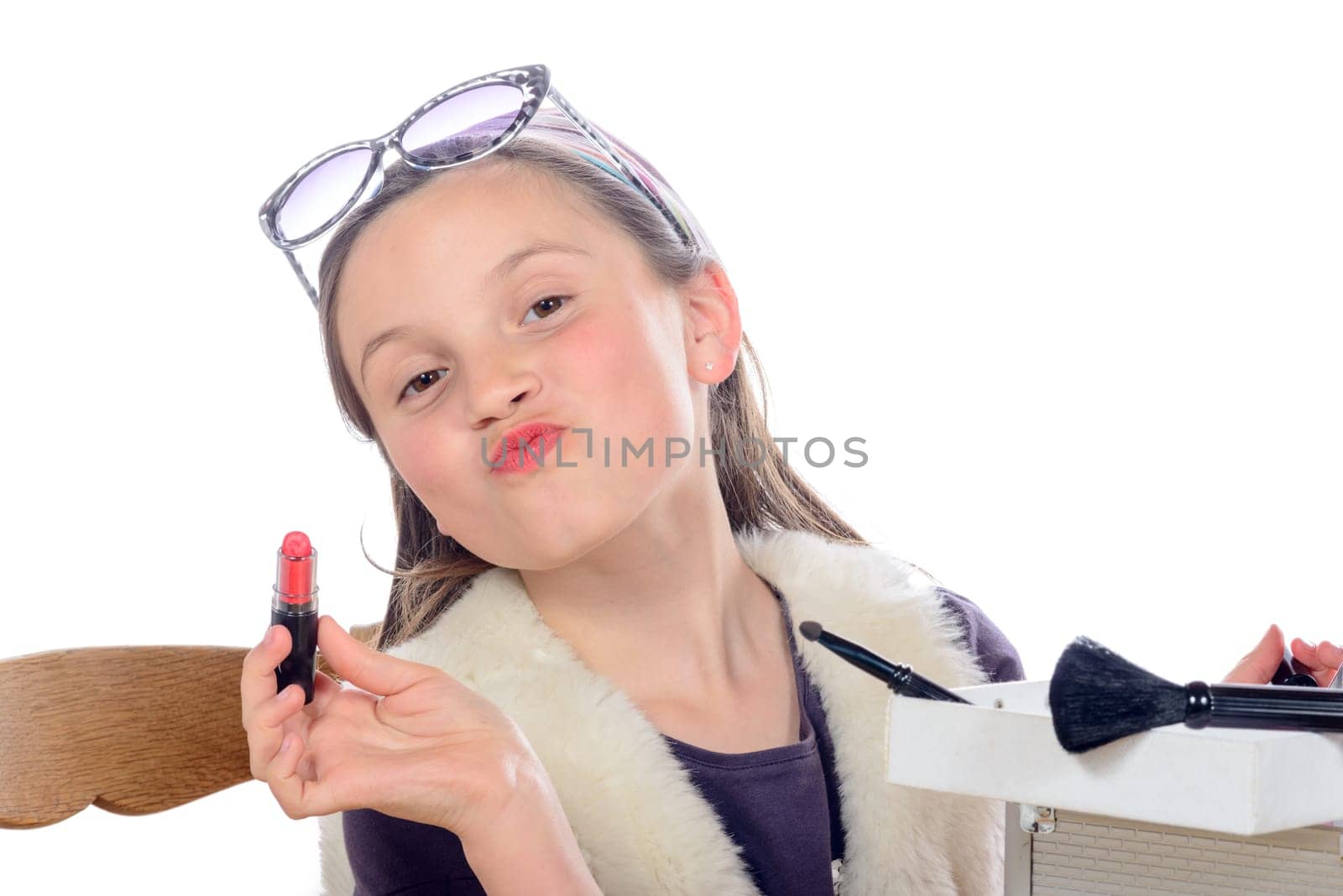 a little girl puts makeup of his mother on white