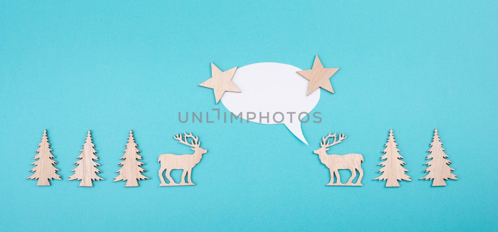 Two cute reindeers talking to each other, speech bubble with copy space, christmas greetings, blue colored background