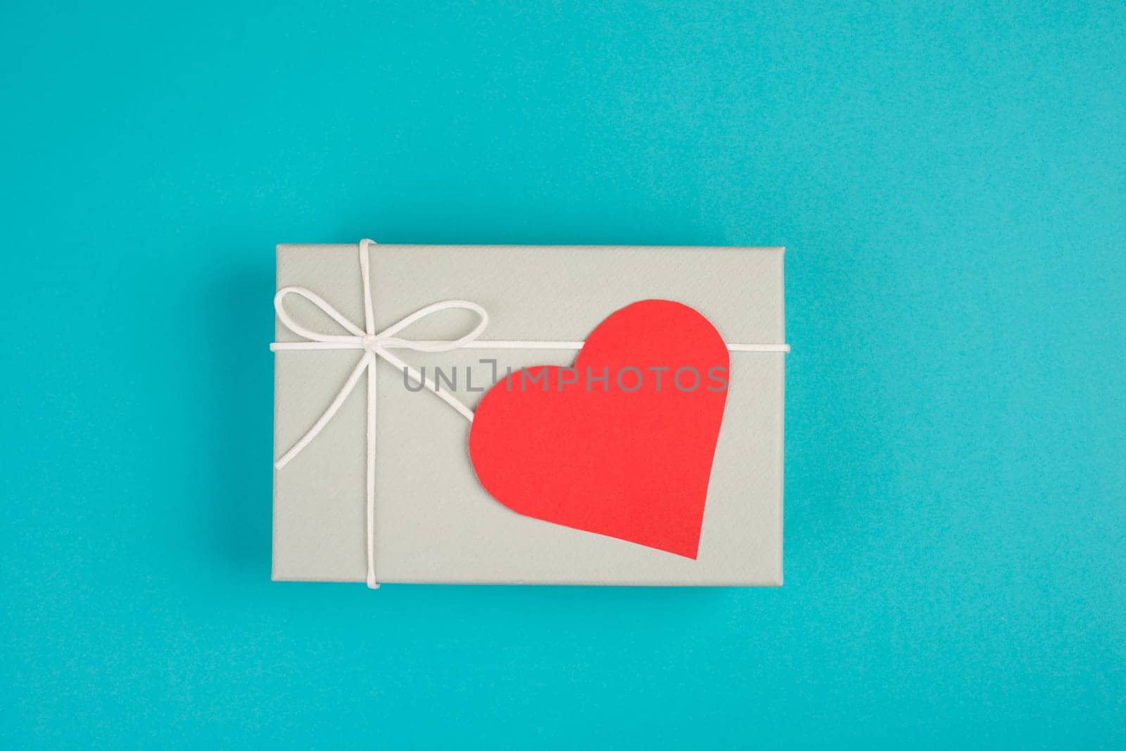 Gift box with a red heart, copy space for text, blue colored background, valintine day, birthday