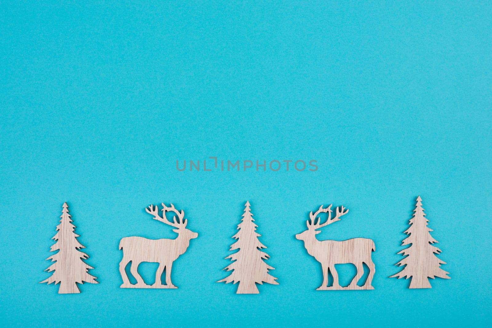 Reindeers, christmas trees, blue colored background, copy space for text, greeting card, winter backdrop