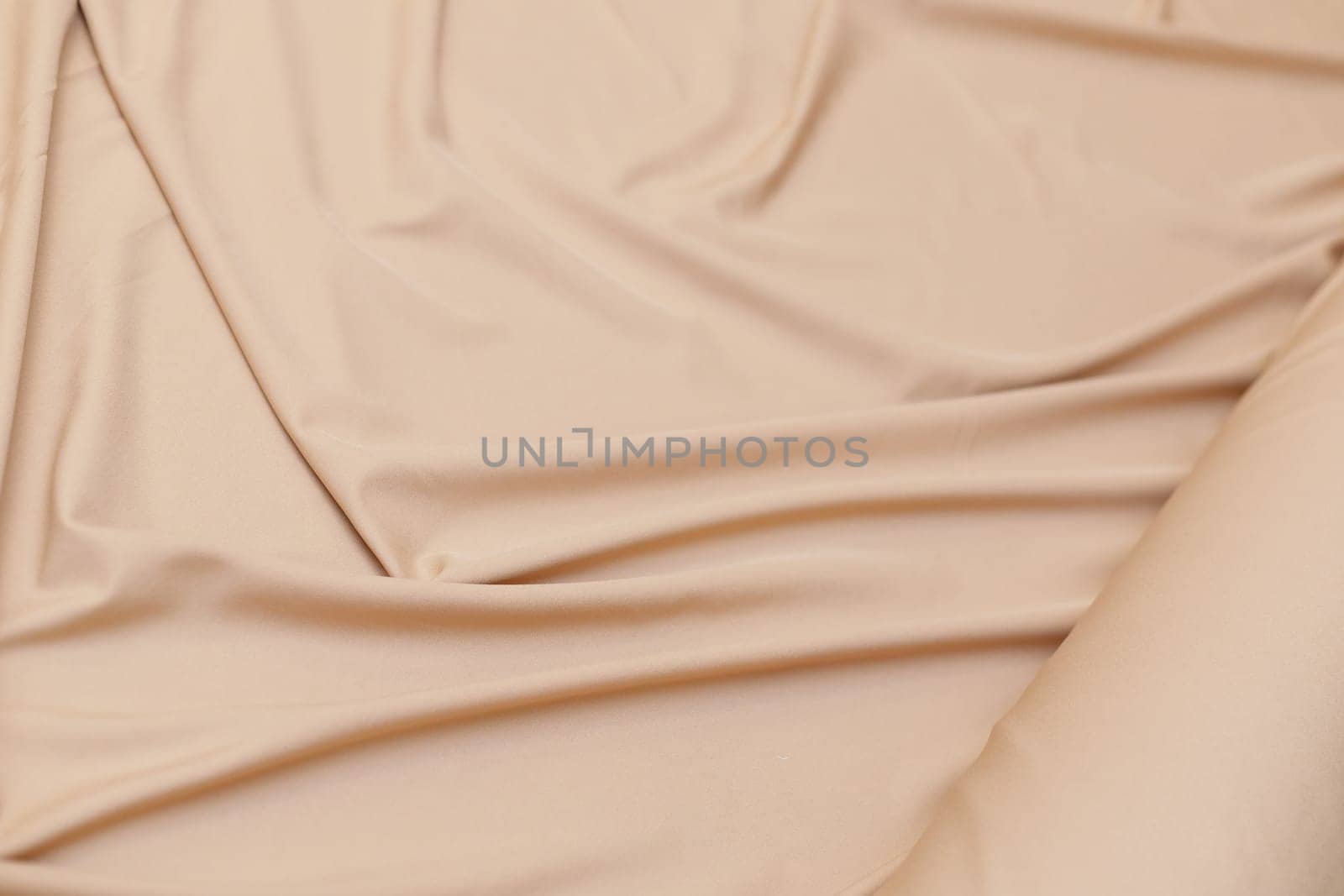 Unwound pastel color fabric roll with wrinkles