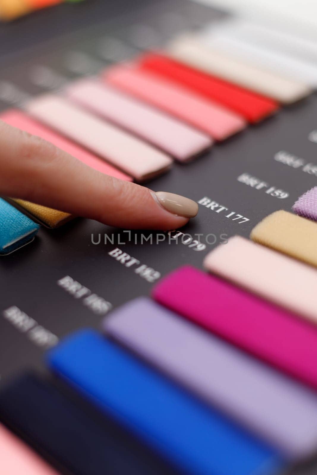 Female hand choosing right colour from catalogue, closeup