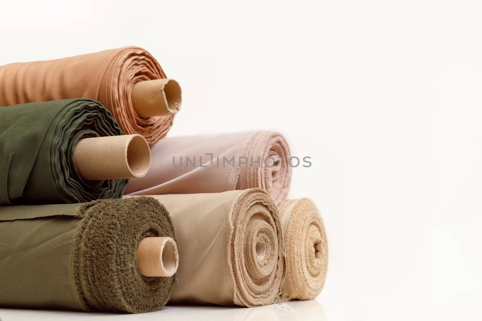 Stack of pastel color fabric rolls isolated on white, Synthetic and natural fabrics with copyspace