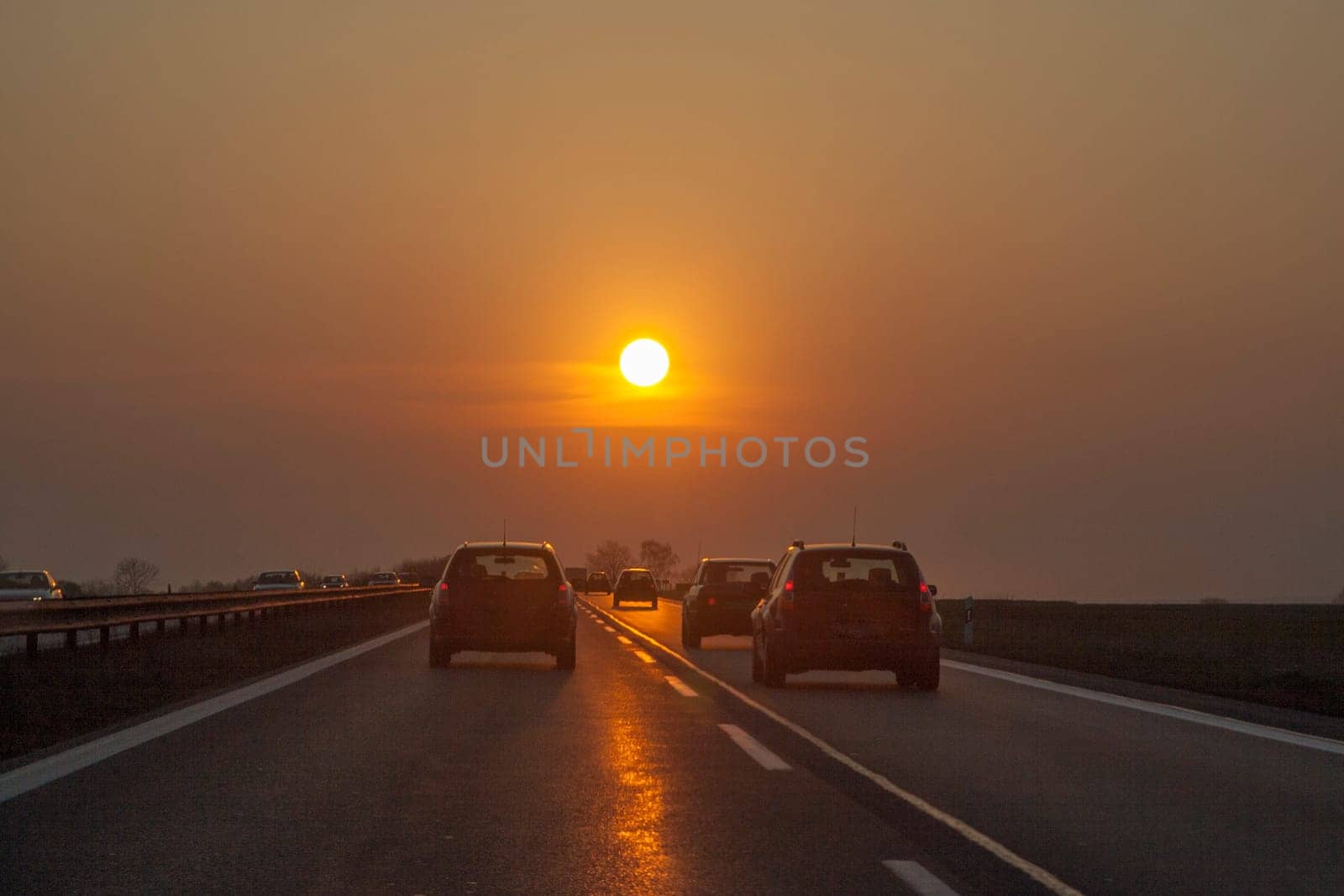 traffic at the european highway with cars and romantic sunset in front