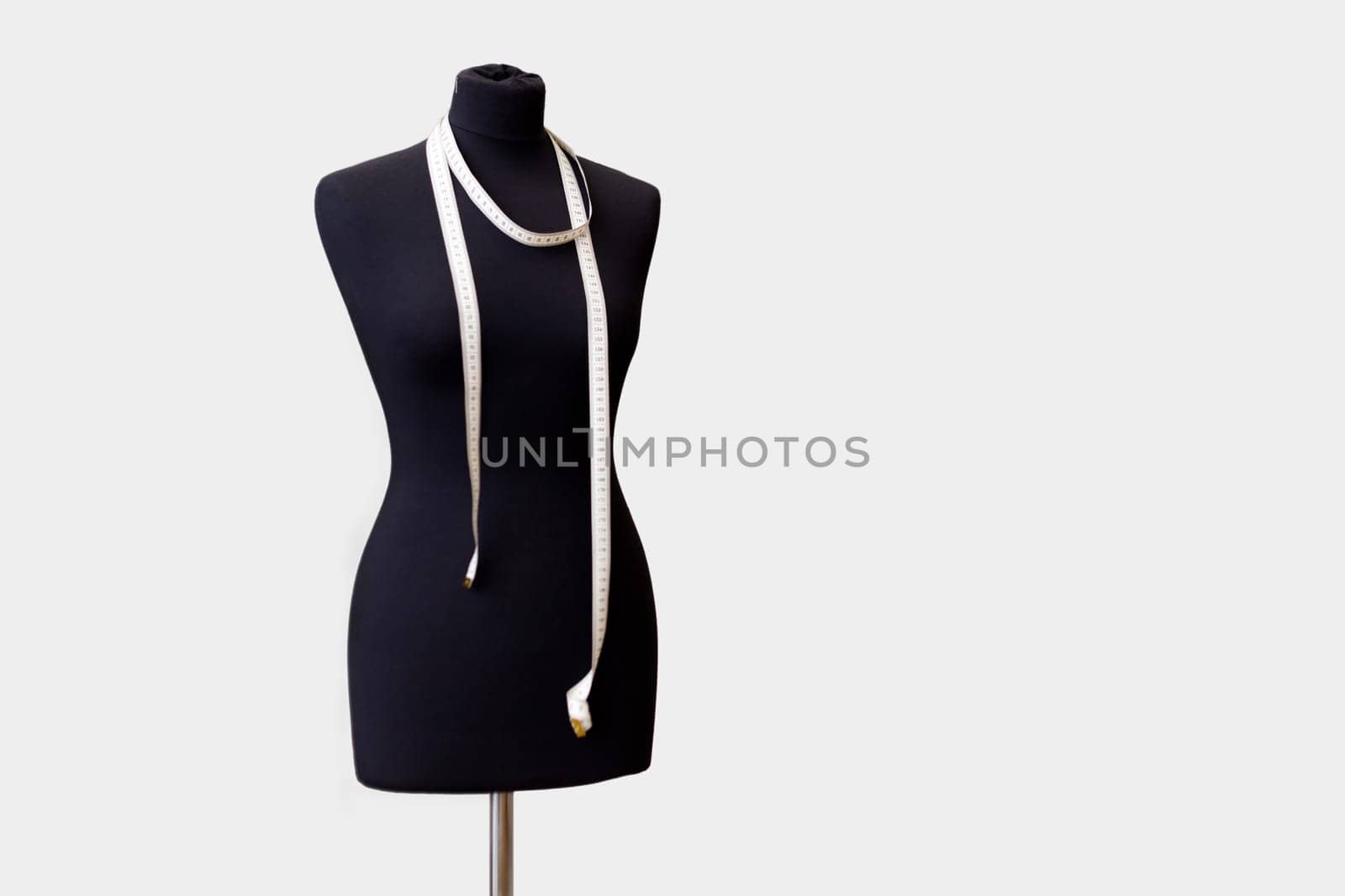 black tailor mannequin for sewing clothes with a measuring tape. full-length mannequin isolated on white