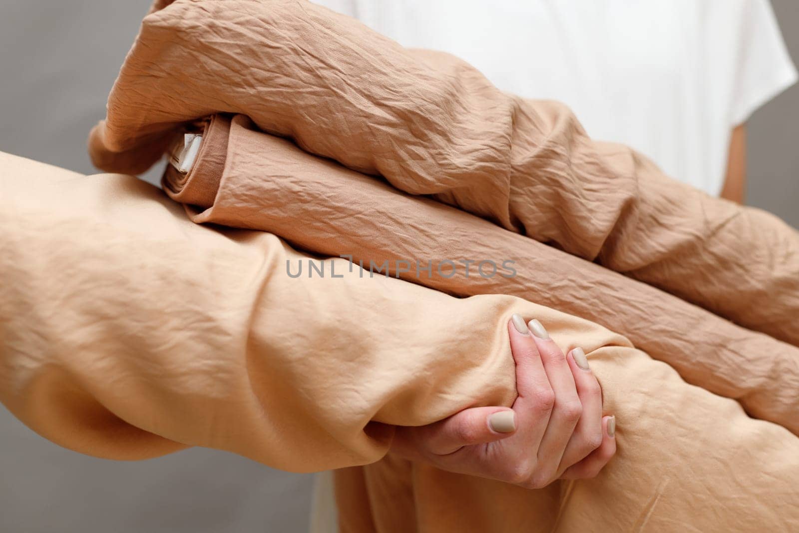 Business woman holding fabric rolls, working at textile shop