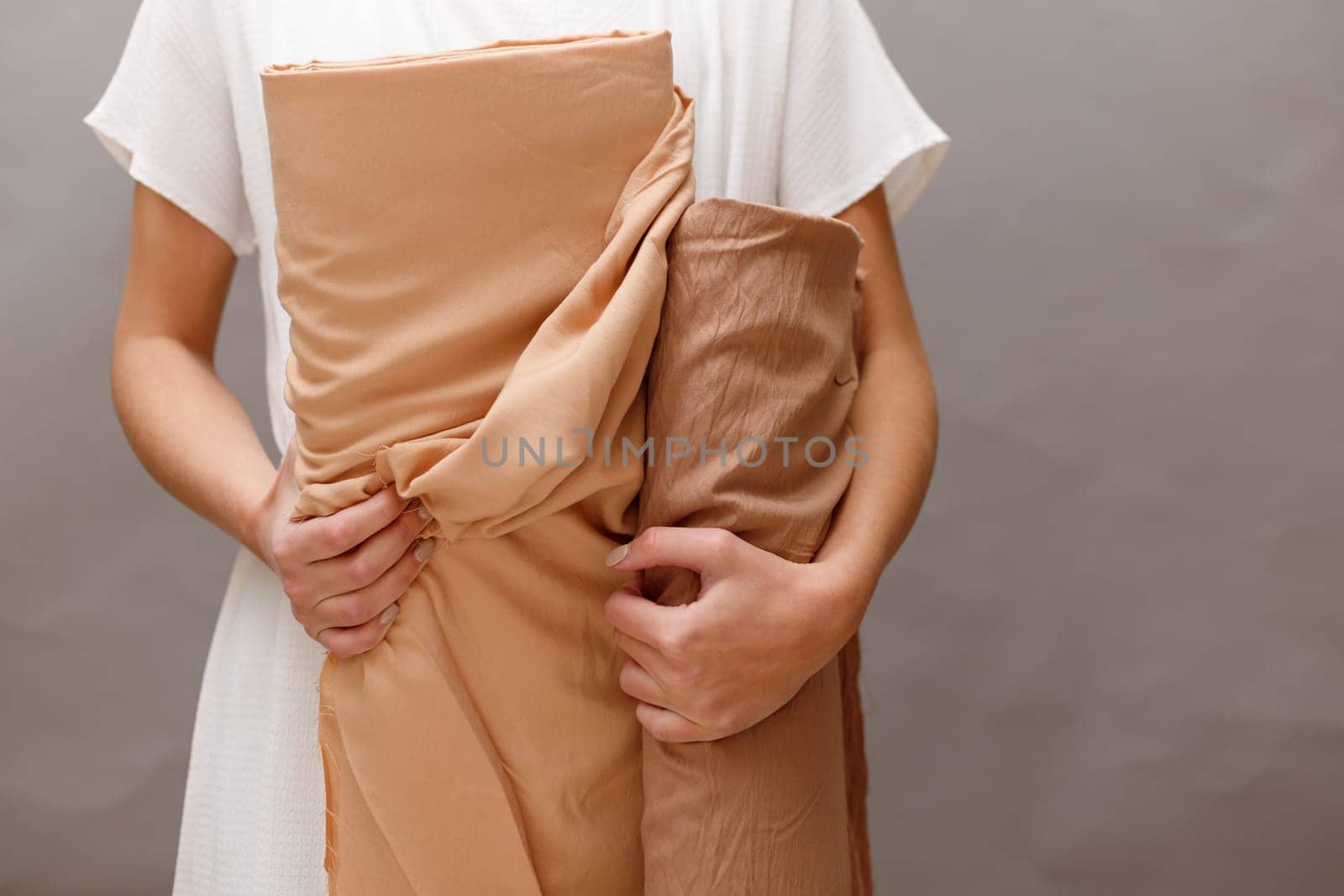 Business woman holding fabric rolls, working at textile shop