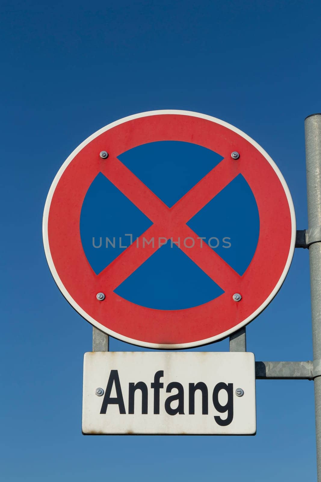 street sign beginning of no stopping under blue sky