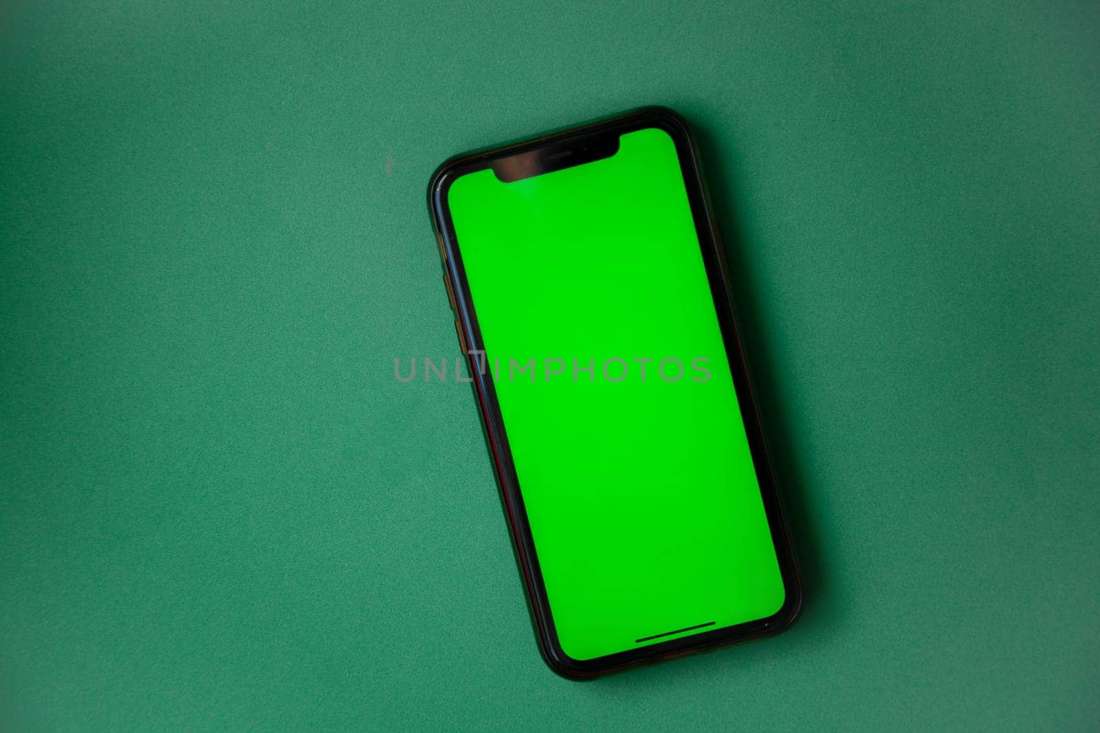 The phone with a green screen is on a green background. . High quality photo