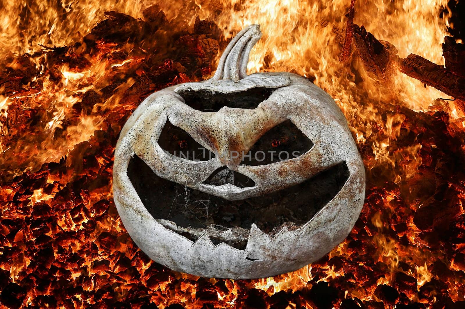 A spooky Halloween pumpkin head in a glowing fire
