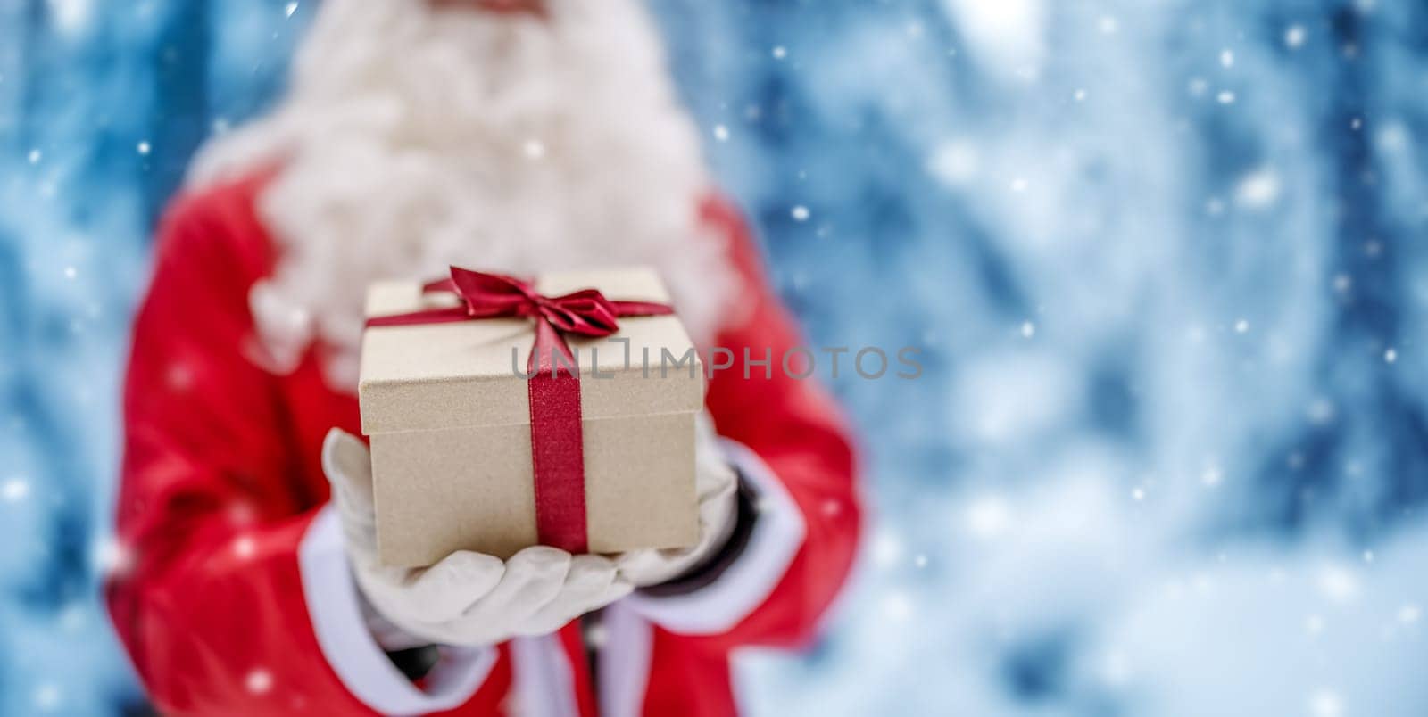 Santa Claus holding in his hands present box. Concept of celebration and holidays.